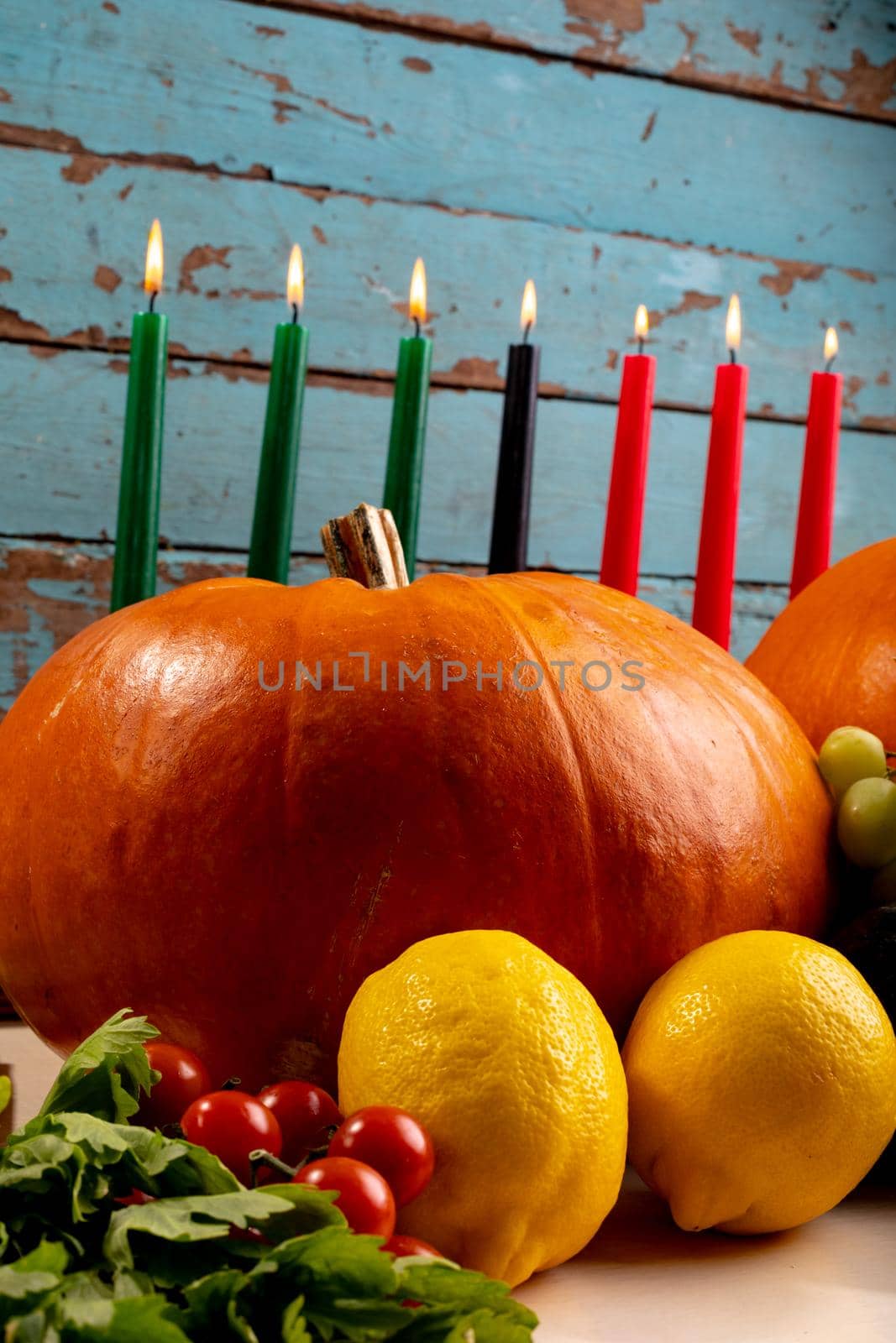 Composition of halloween decoration with candles and pumpkins on wooden background by Wavebreakmedia