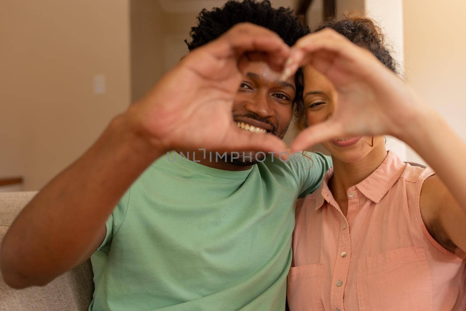 Biracial couple making heart shape with hands gesturing love at valentine's day by Wavebreakmedia