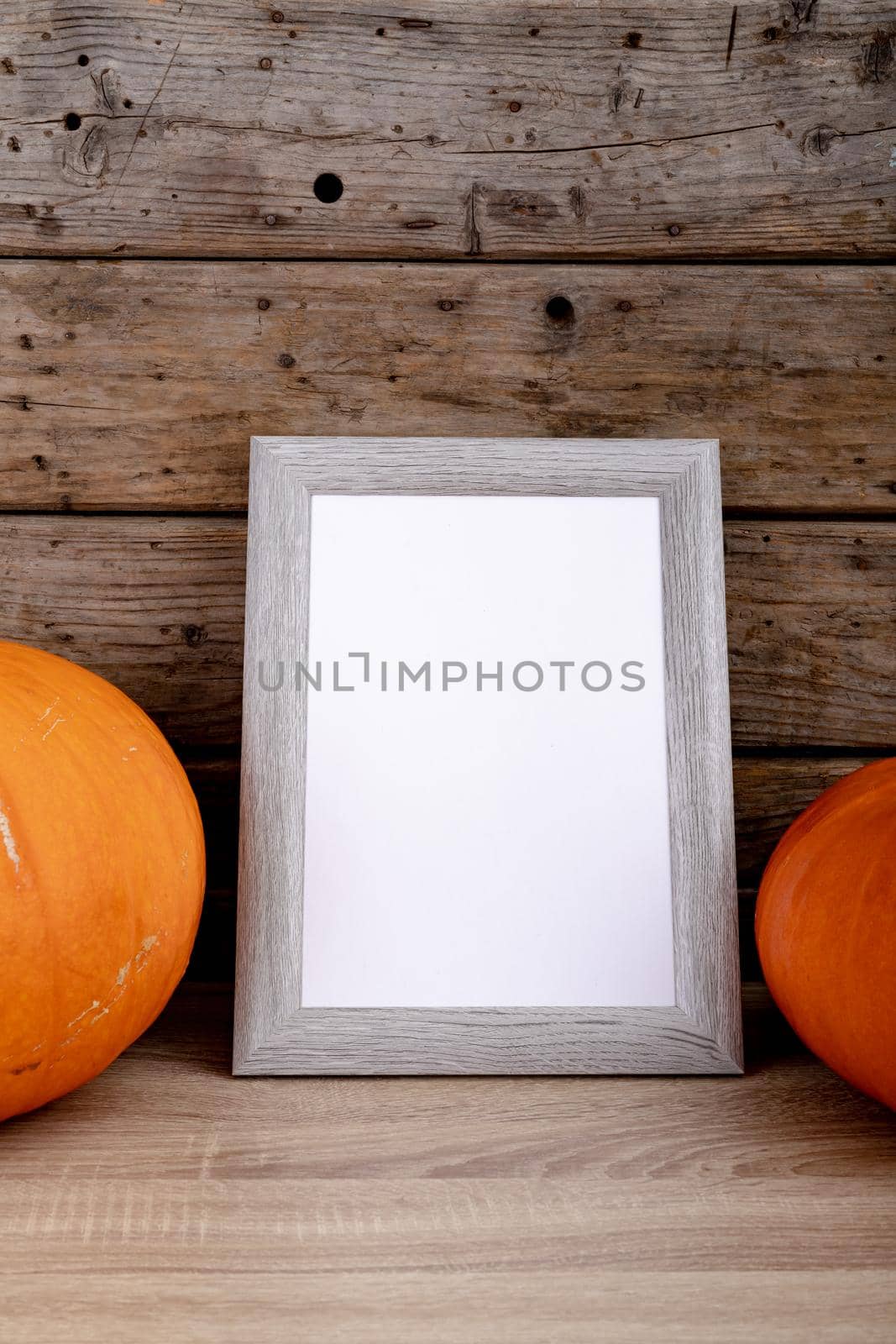 Composition of halloween decoration with pumpkins and frame with copy space on wooden background. halloween tradition and celebration concept digitally generated image.