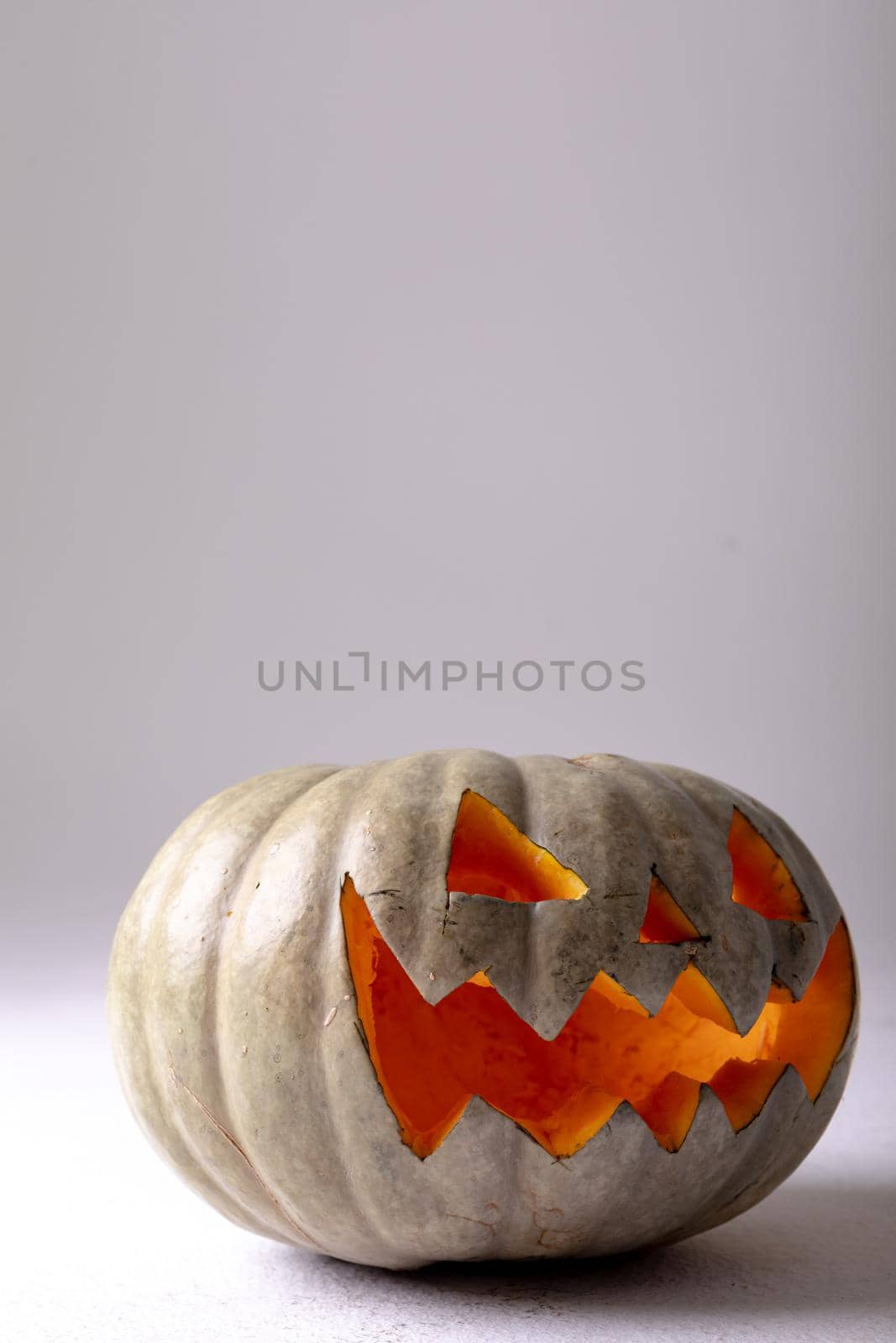 Composition of halloween jack o lantern and copy space on grey background by Wavebreakmedia