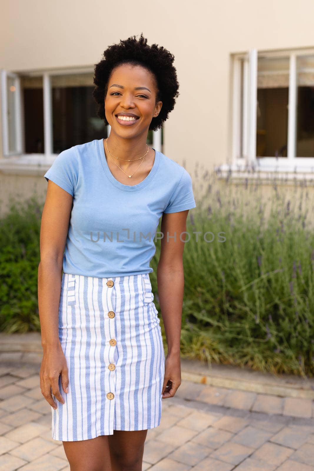 Portrait of happy african american young woman smiling while standing outdoors. people and emotions concept, unaltered.