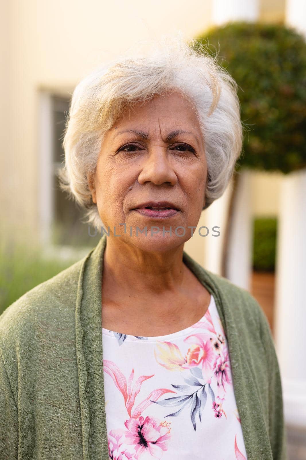 Portrait of senior african american woman with short white hair at backyard by Wavebreakmedia