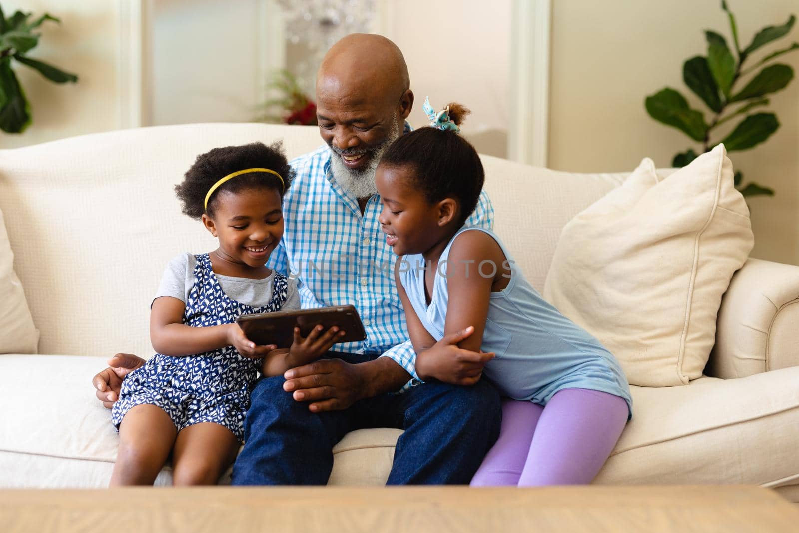 African american grandfather and his two granddaughters using digital tablet at home by Wavebreakmedia