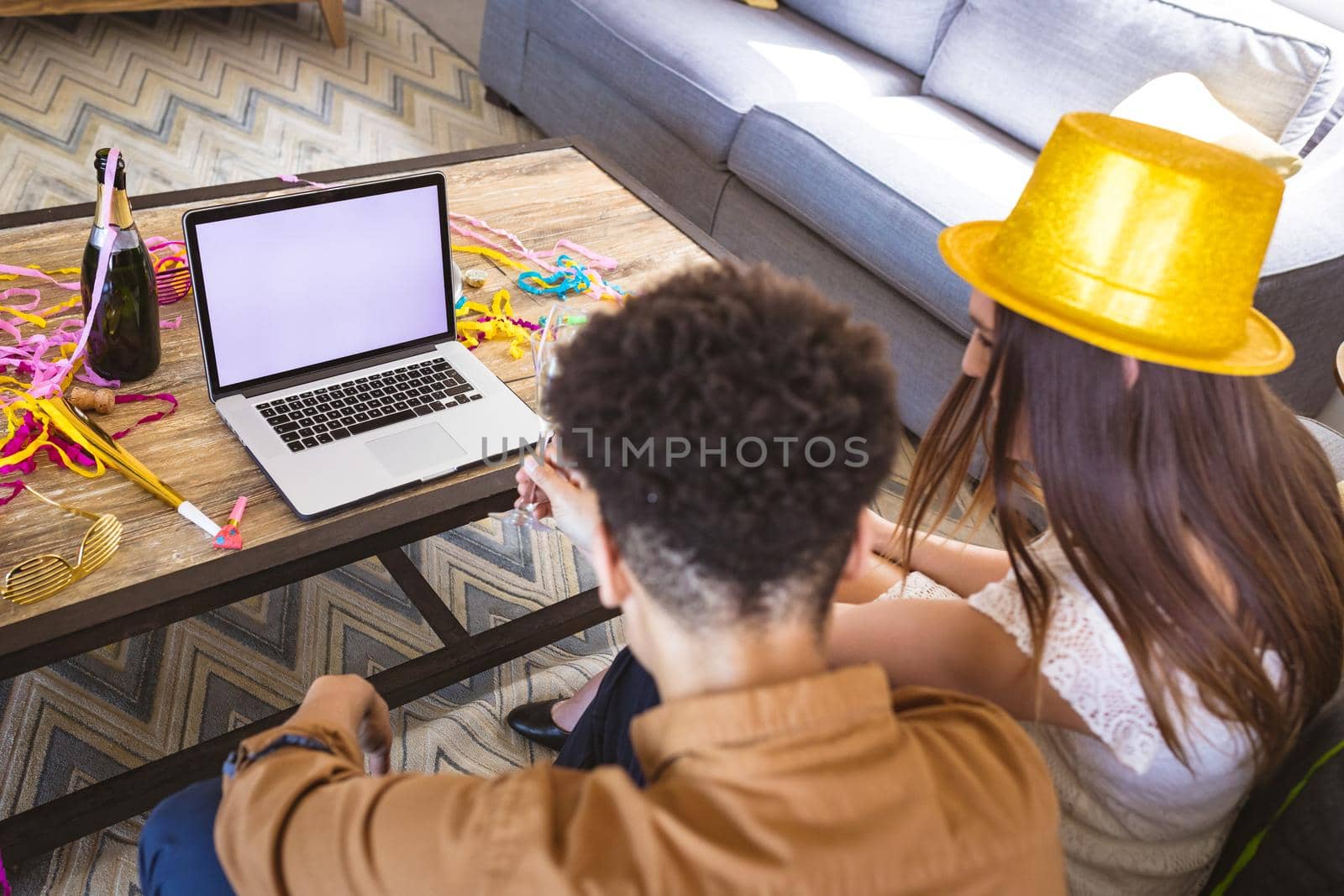 Biracial couple enjoying virtual party through video call on laptop with copy space by Wavebreakmedia