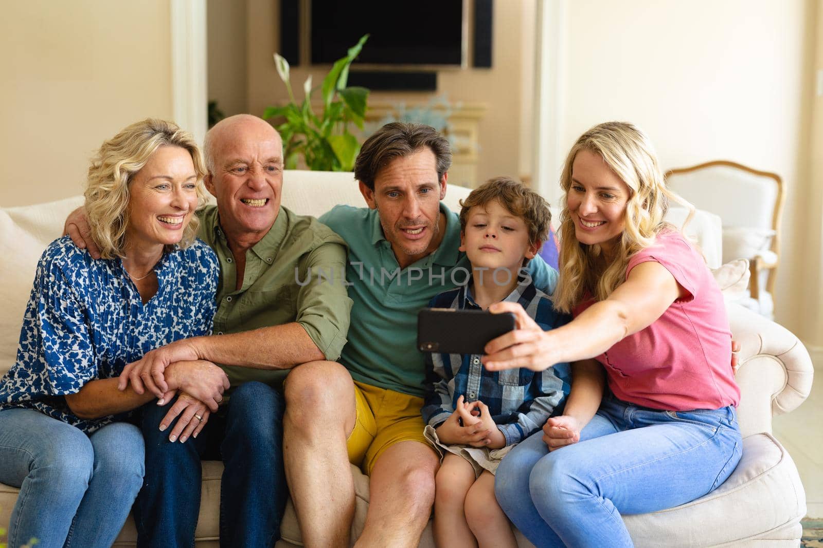Caucasian three generation family taking a selfie while sitting together on the couch at home by Wavebreakmedia