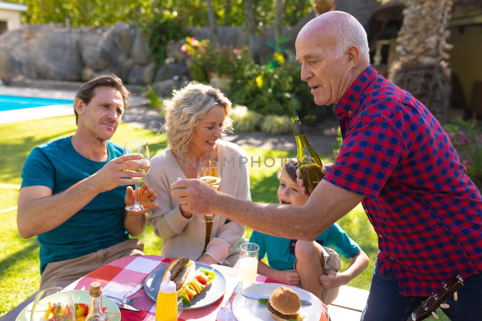 Caucasian senior man serving drinks for the family in garden by Wavebreakmedia