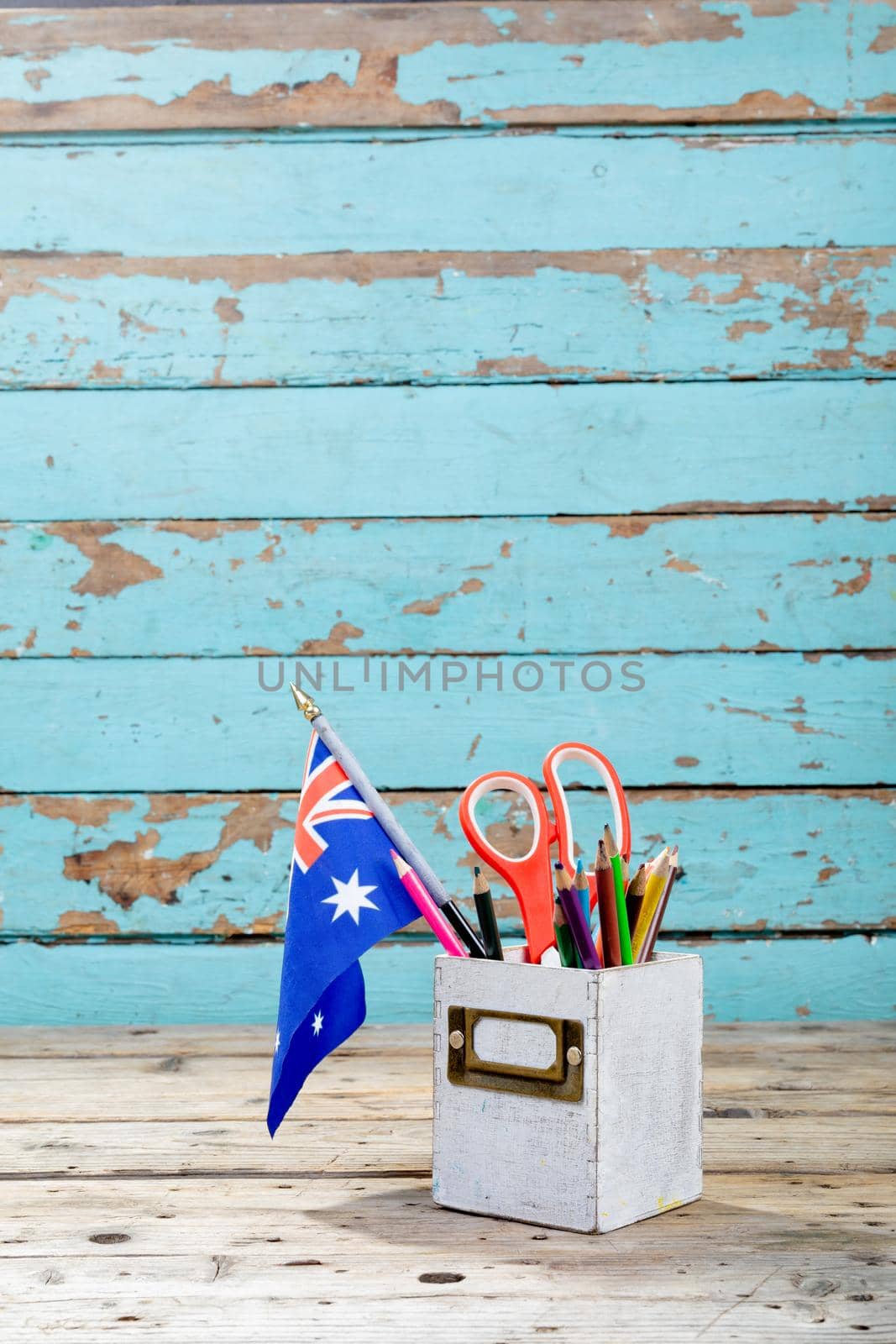 Desk organizer with office supply and australia flag on table against wooden wall by Wavebreakmedia