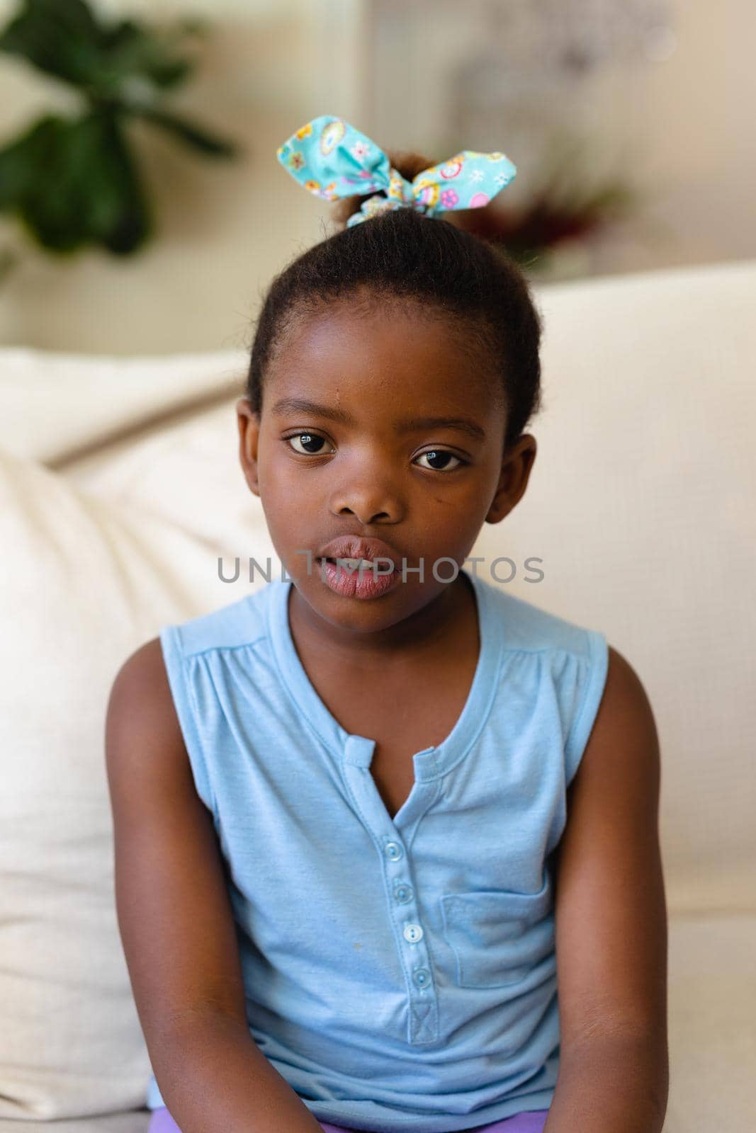 Portrait of african american girl sitting on the couch at home by Wavebreakmedia