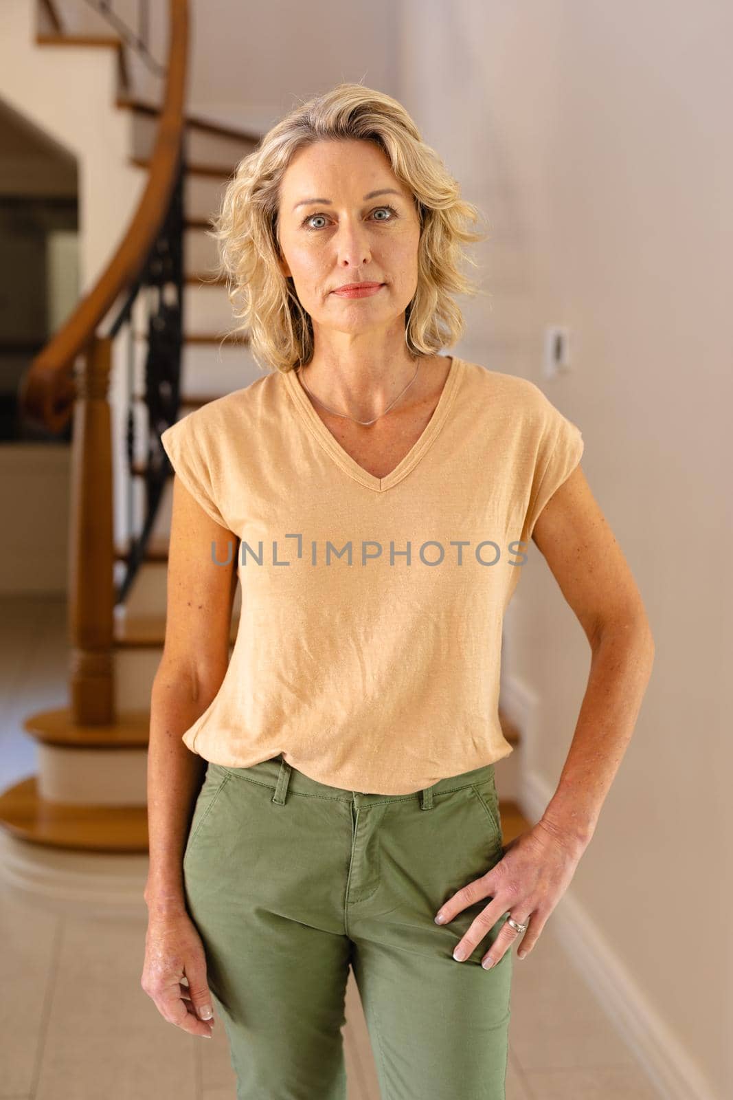 Portrait of caucasian senior woman while standing in the living room at home. people and emotions concept, unaltered.