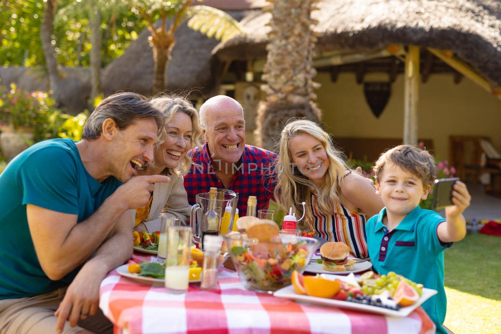 Cheerful caucasian three generation family taking a selfie with smartphone in the garden by Wavebreakmedia