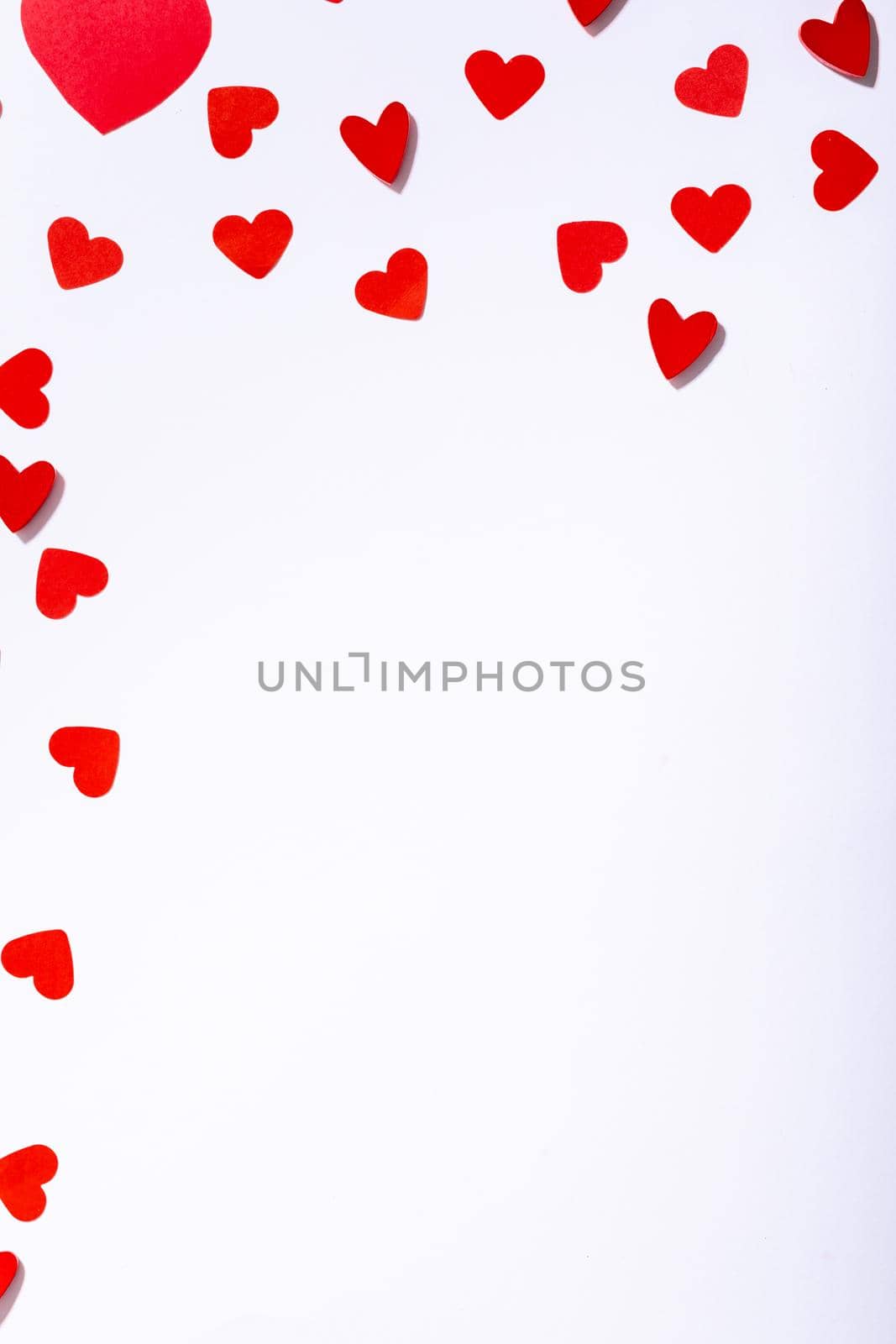 Overhead view of red heart shape cutting decoration scattered with copy space on white background. love and valentine.