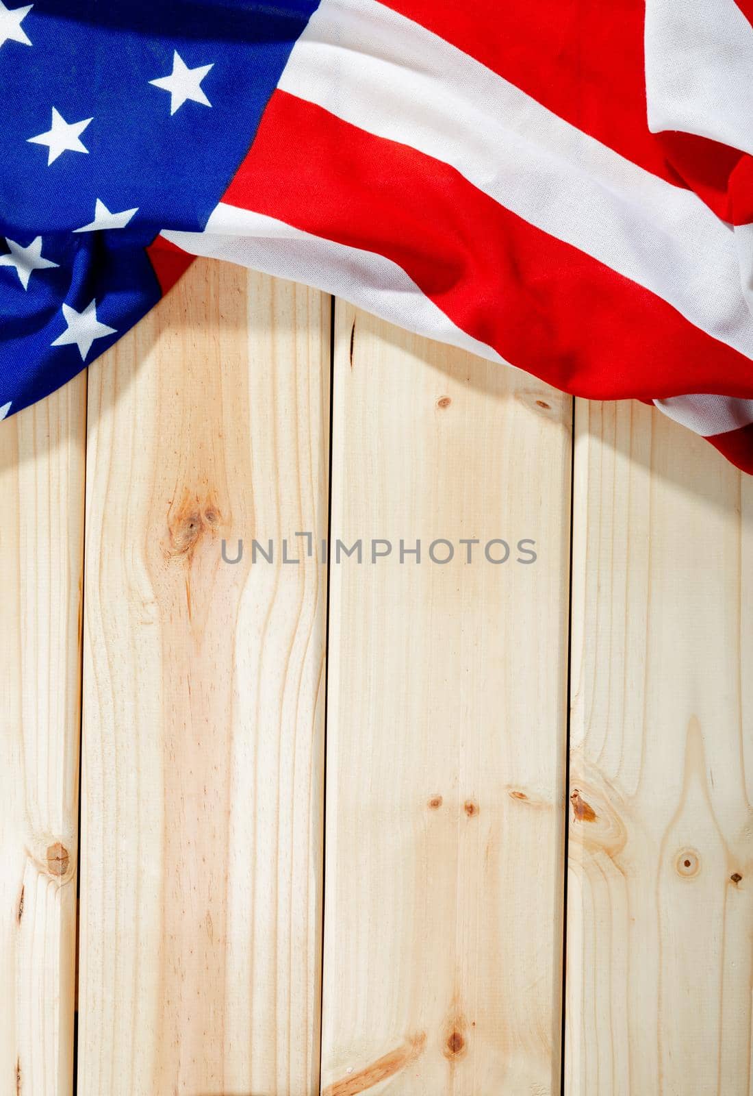 Overhead view of red and white stripes along with stars on america flag over wooden table. patriotism, identity and copy space.