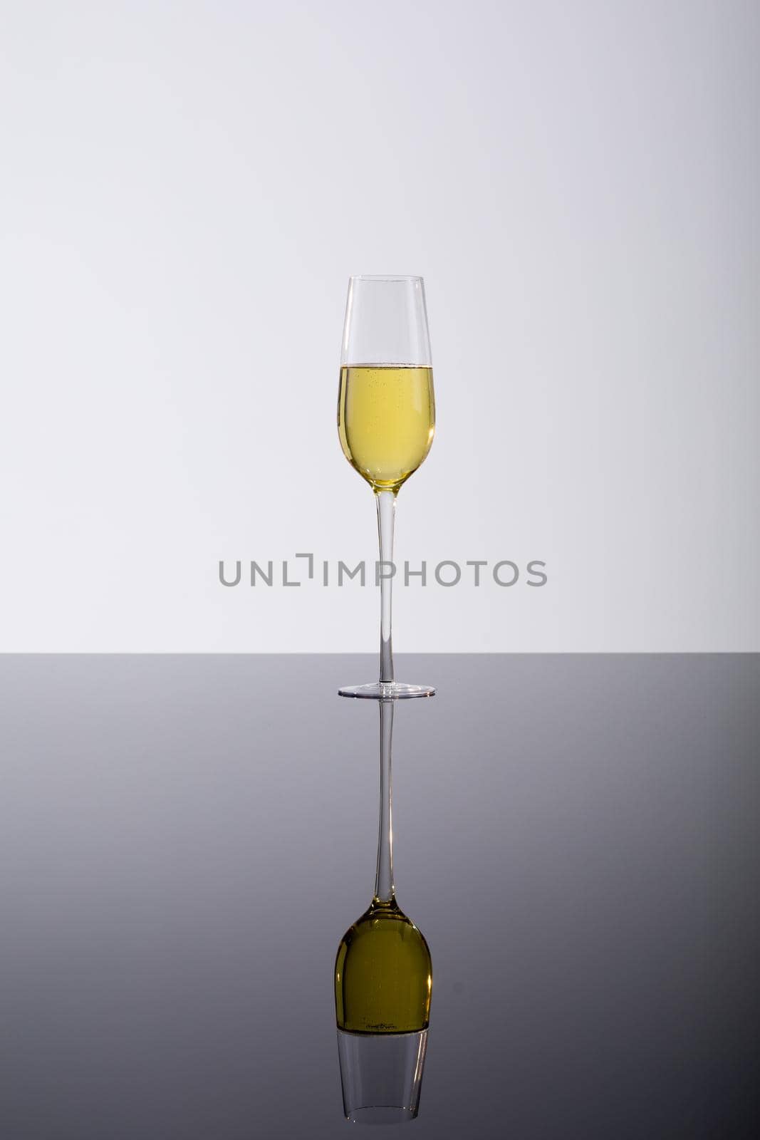 Closeup of champagne flute with reflection on glass table, drink against white background by Wavebreakmedia