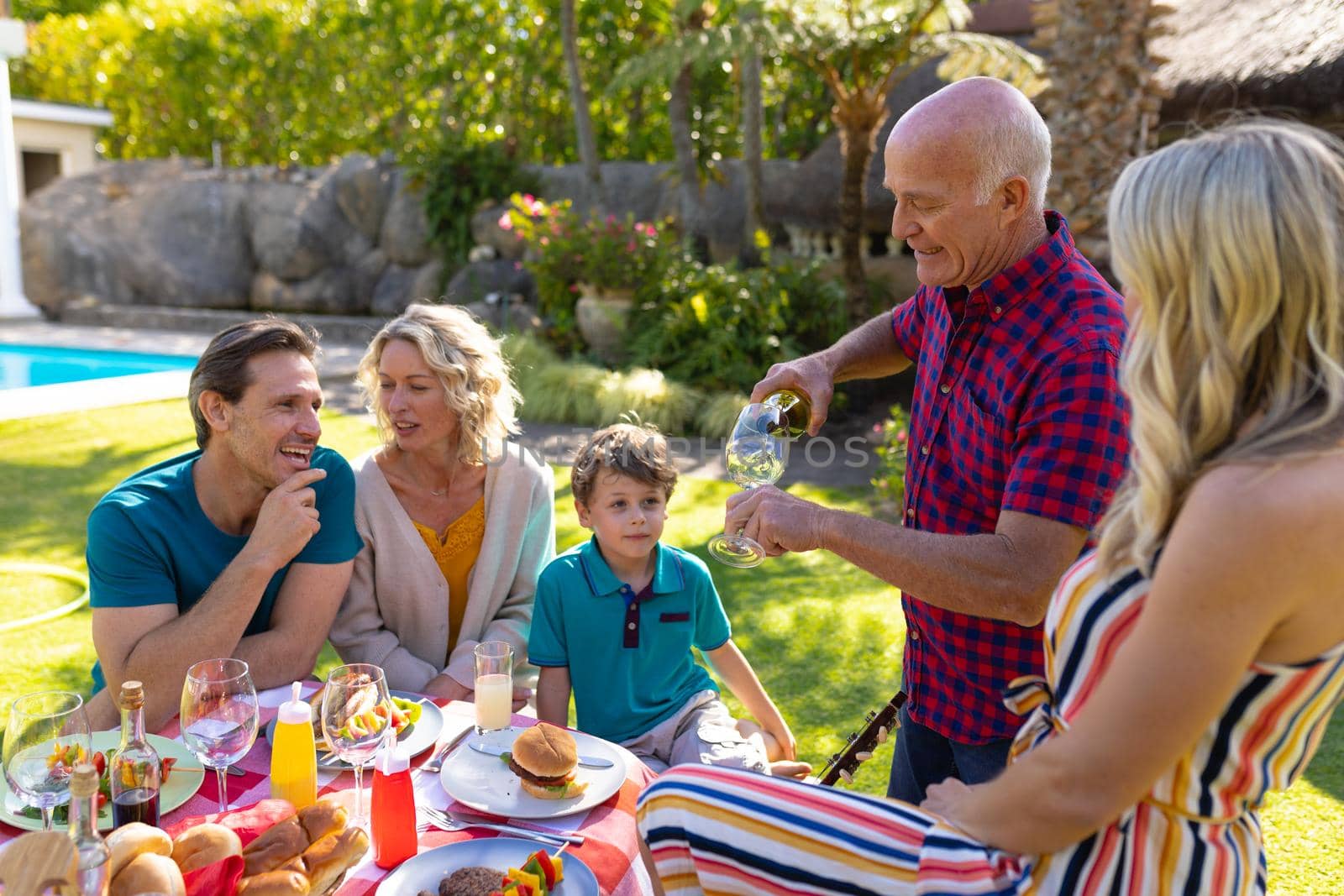 Caucasian three generation family enjoying lunch in the garden by Wavebreakmedia