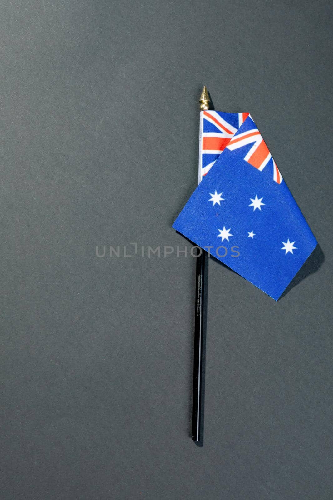 Overhead view of stars and union jack on australia flag stick by copy space over black table. patriotism, symbol and identity.