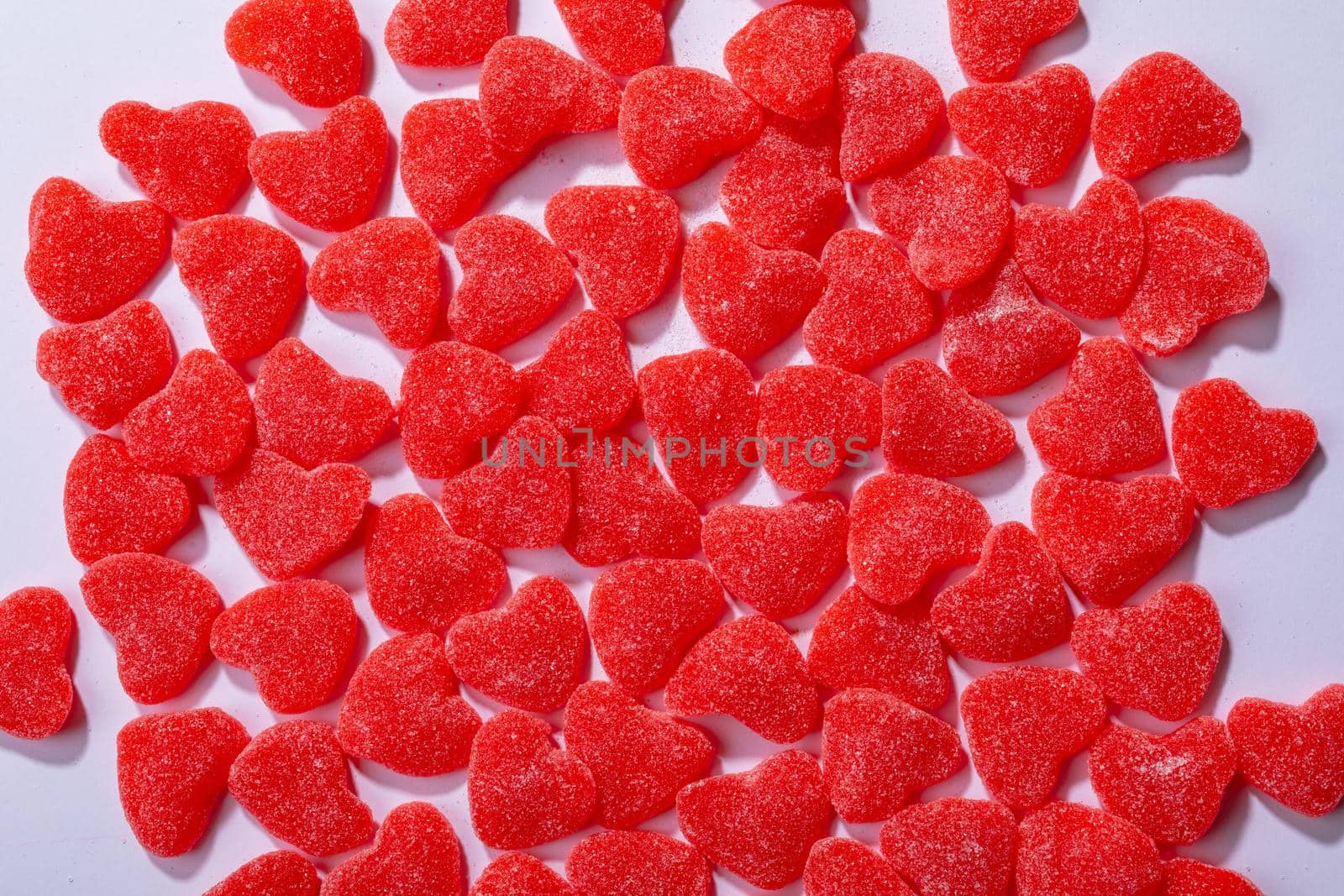 Overhead view of heart shaped red candies on white background, copy space. valentine's day, food and love concept.