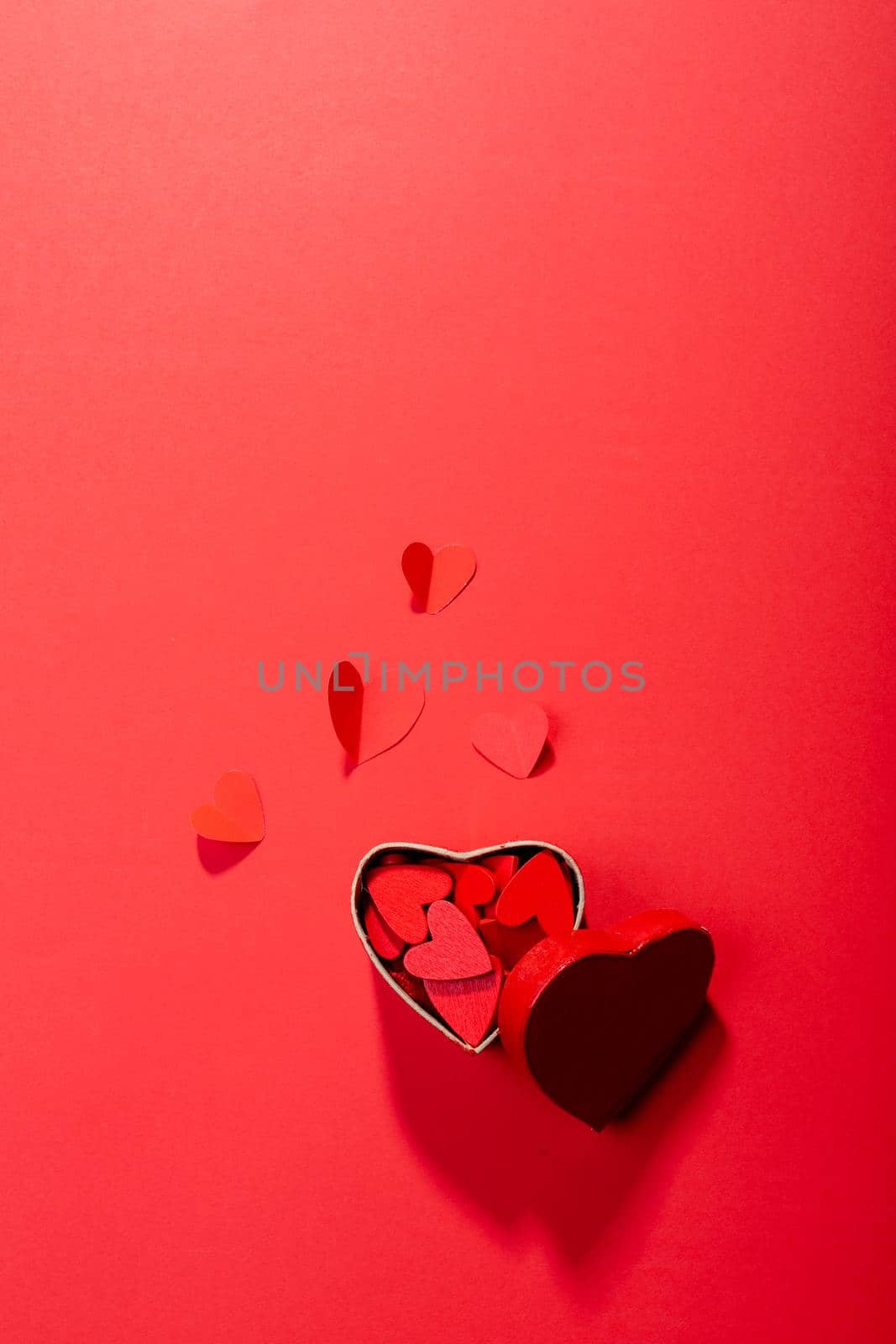 Directly above view of heart shaped decoration and gift box on red background, copy space by Wavebreakmedia