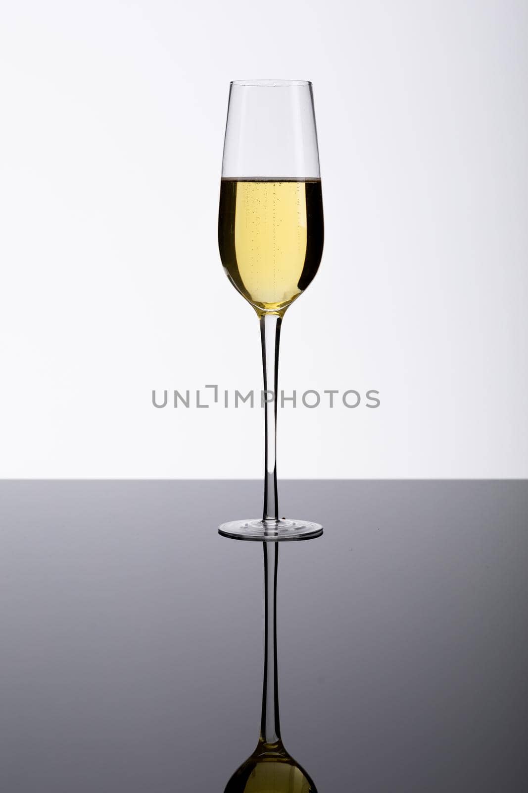 Champagne flute on glass table isolated over white background, copy space. drink, celebration and studio shot.