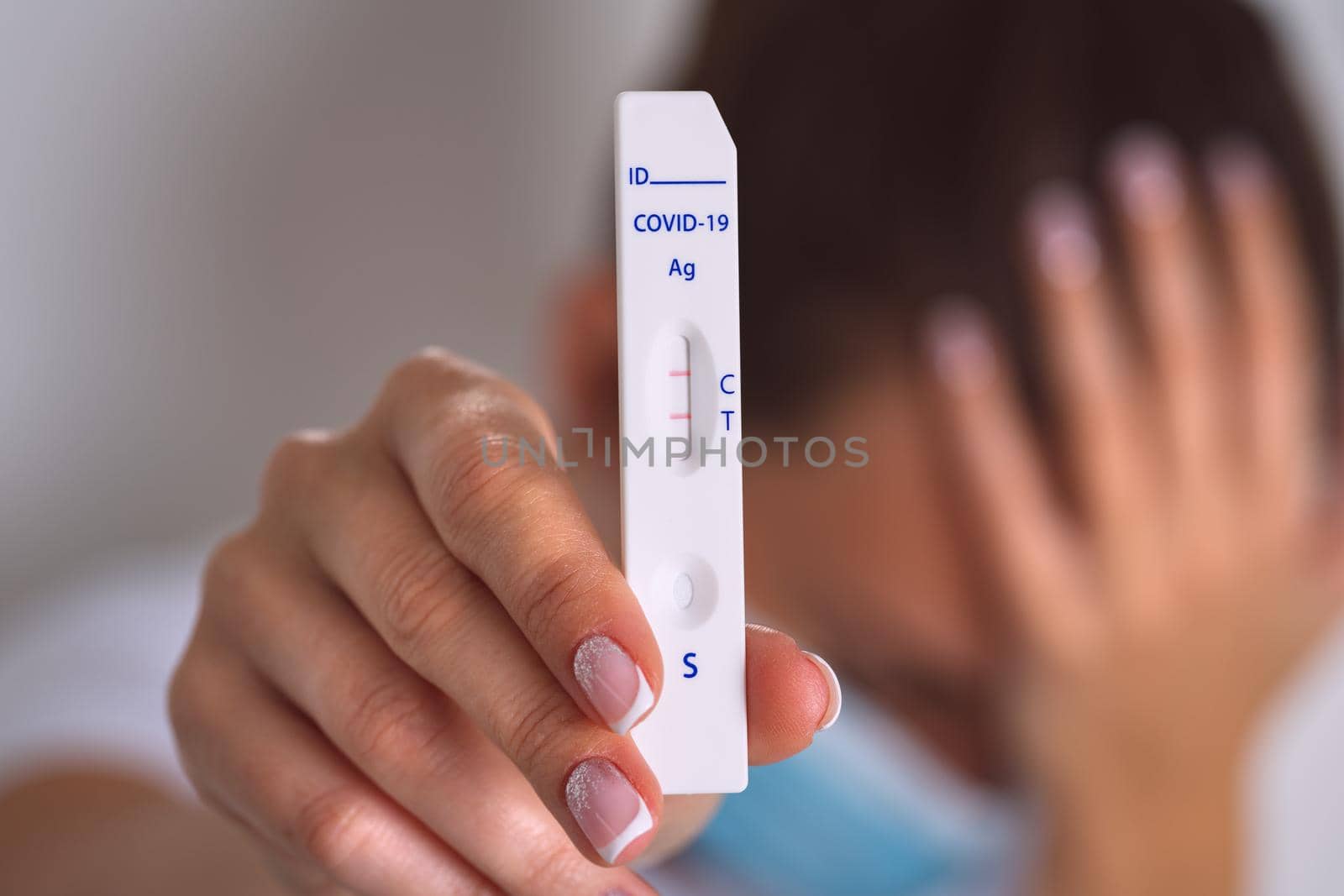 Sad woman showing rapid covid antigen test or express covid test with positive coronavirus result. Woman with covid-19 infection. High quality photo