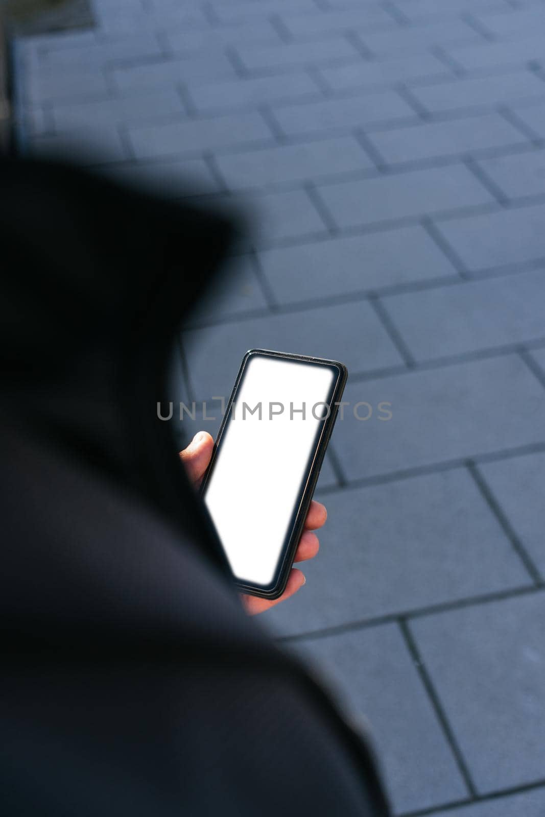 young business man looking phone near to office. Natural light in a sunny day. Smartphone with white screen to paste anything