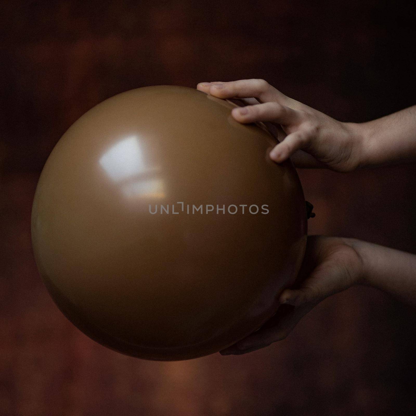 children's toys are diverse fantasies and dreams take the child's imagination into fantastic unreal game worlds in the photo the girl's hands are holding a brown balloon by Costin