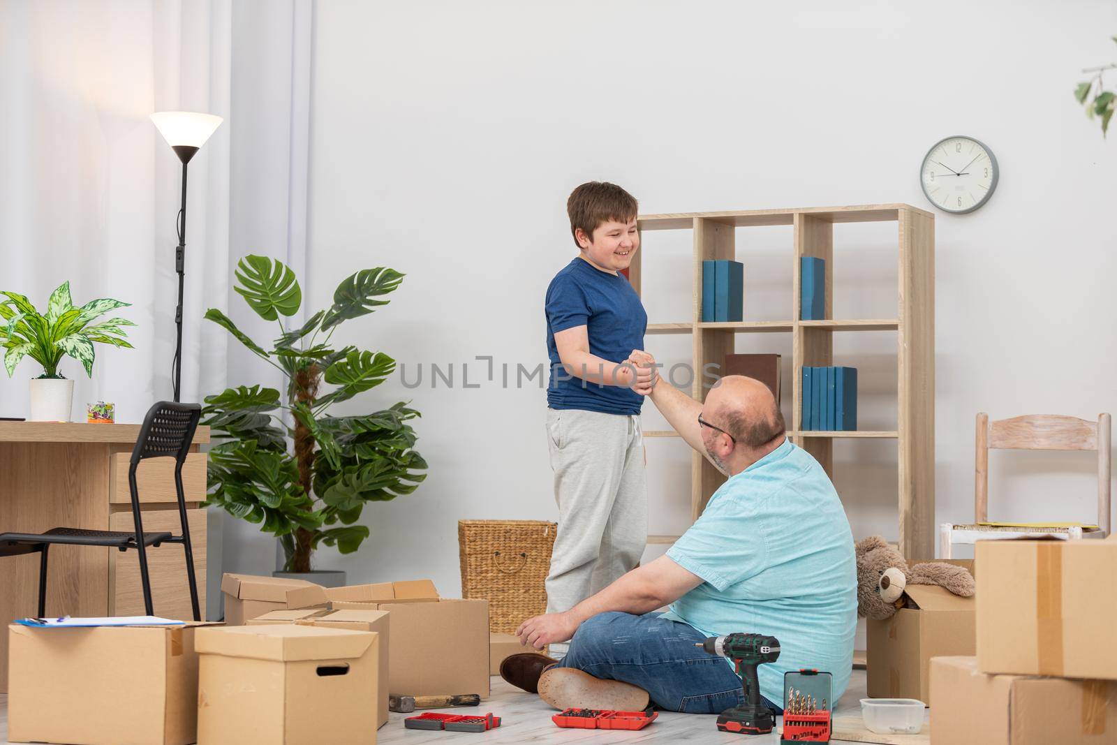 A father and his son shook hands at the end of a job at home. by fotodrobik