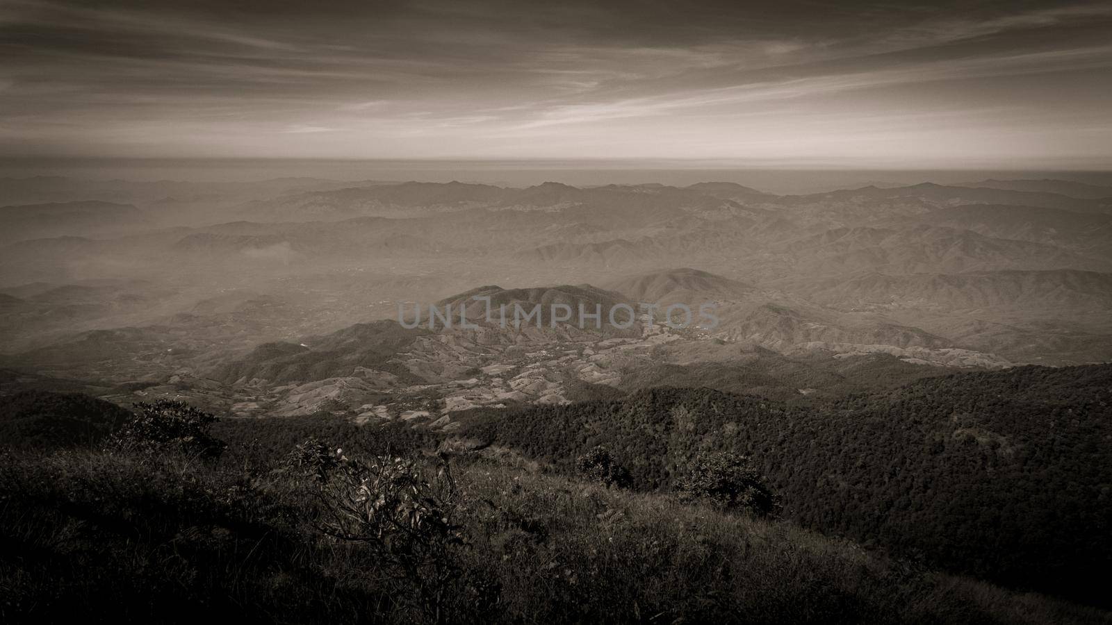 Beautiful landscape silhouette on the mountain peak during sunset with warm sunlight and dramatic sky. vintage tone