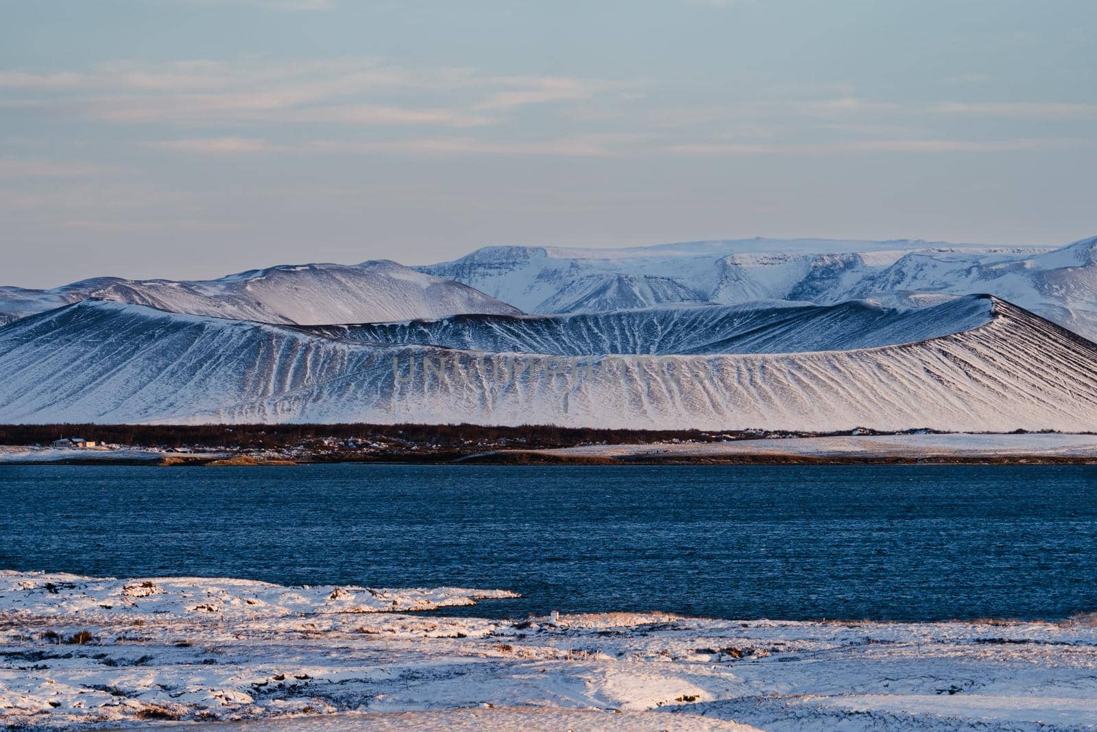 Volcano crater over the lake covered by snow in Myvatn lake, Iceland