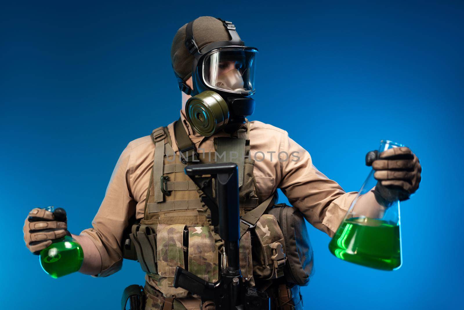 a man in military clothes and a gas mask with laboratory chemical flasks