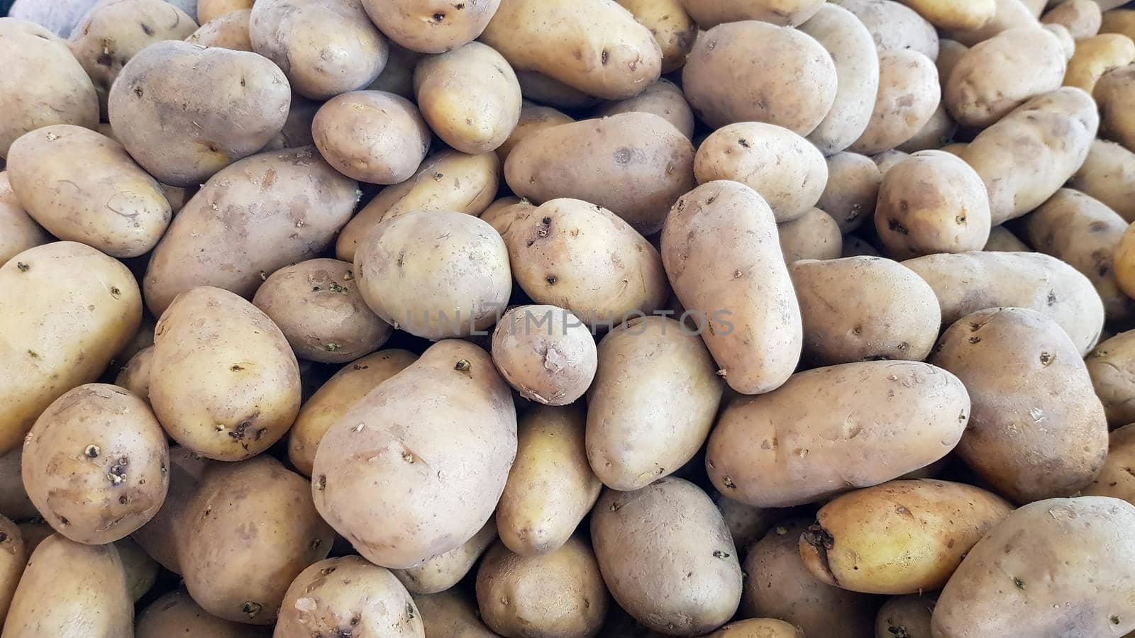 Lots of potato tubers are placed on shelves for sale in a department store in Thailand. by pichai25