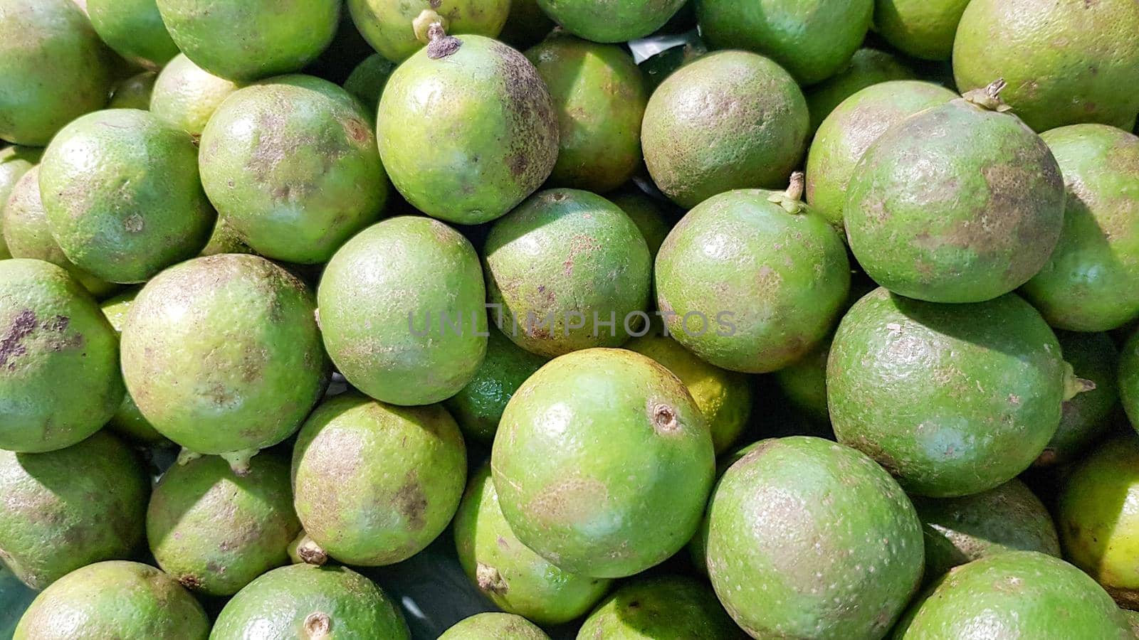 Many green limes are put on the shelves for sale. by pichai25