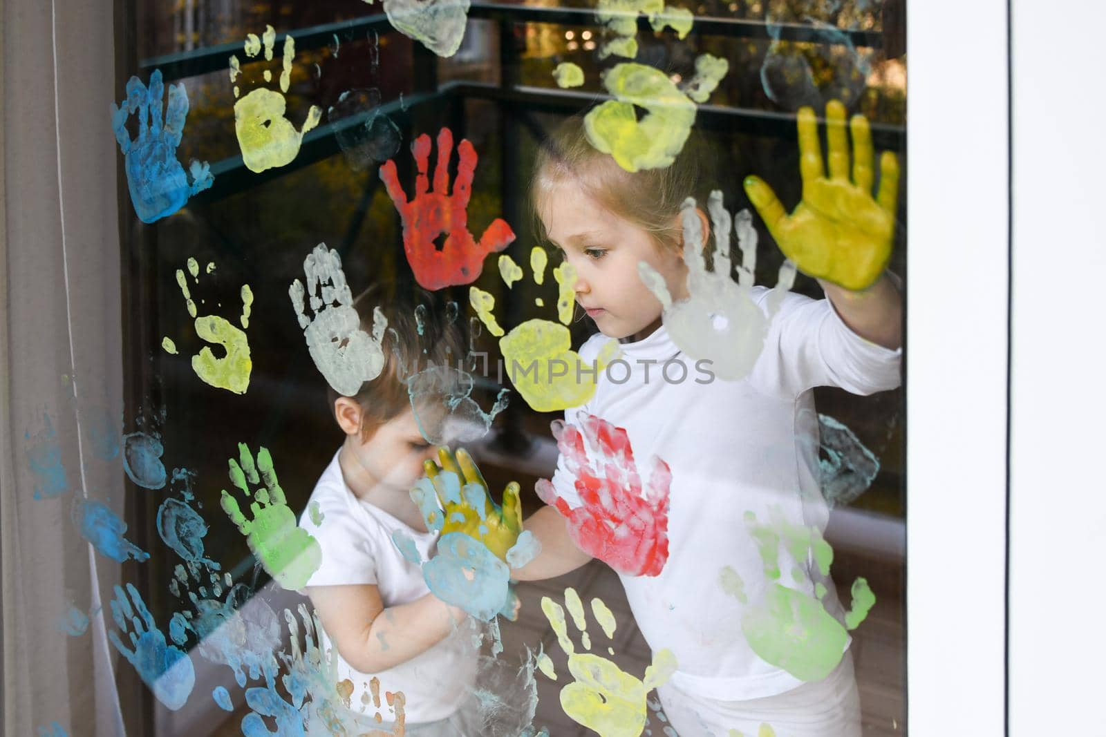 The kids paint with palms on the window. Quarantine Stay at home