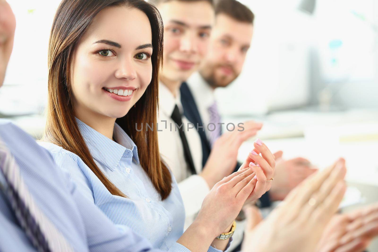 Portrait of colleagues sitting in row clap in hands for successful business agreement. Happy coworkers celebrating deal in office. Growth, career concept