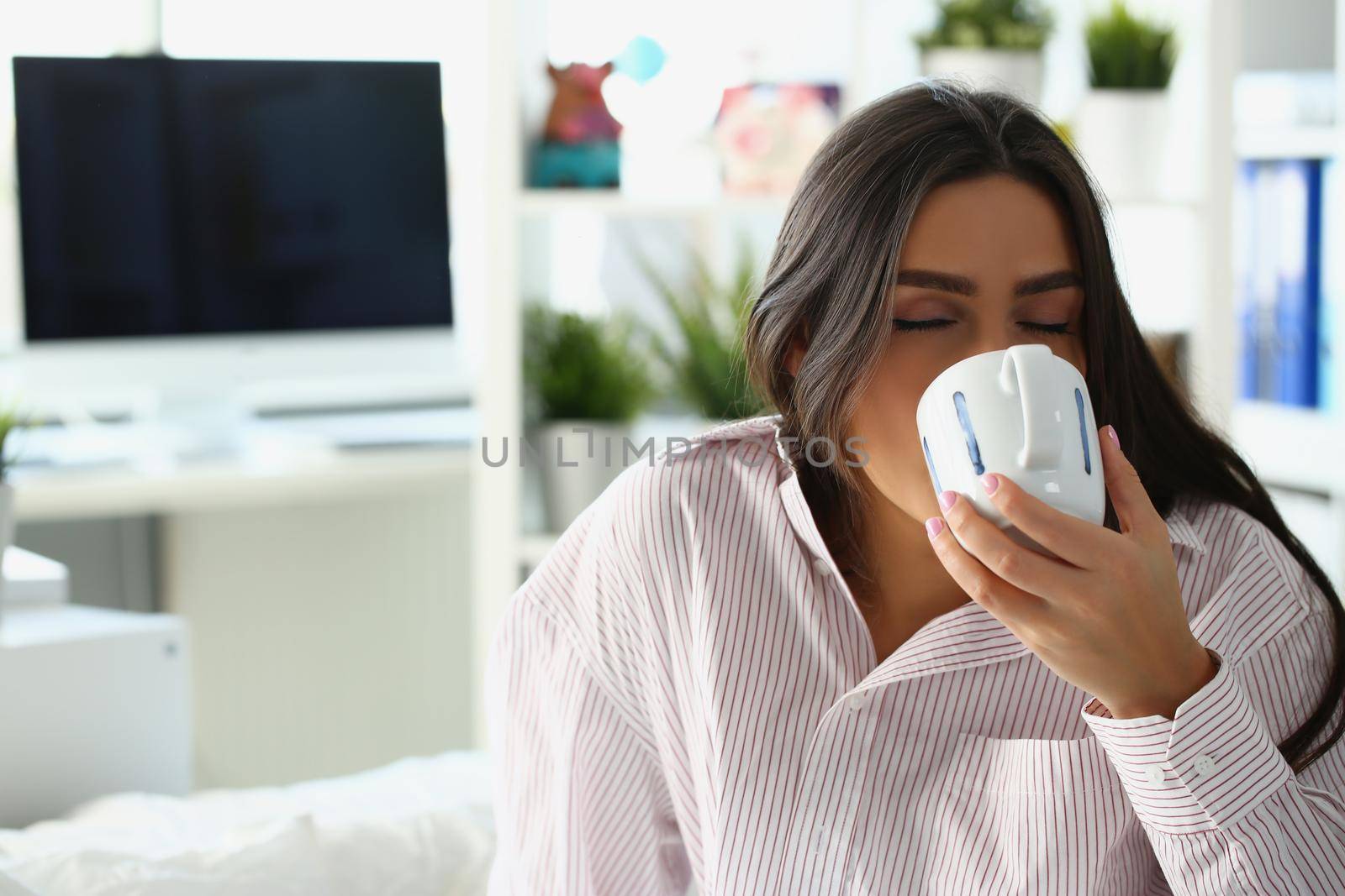 Portrait of lovely sleepy woman drink coffee to wake up in morning, caffeine for energetic day start. Lady in pyjamas at home. Good morning, ritual concept
