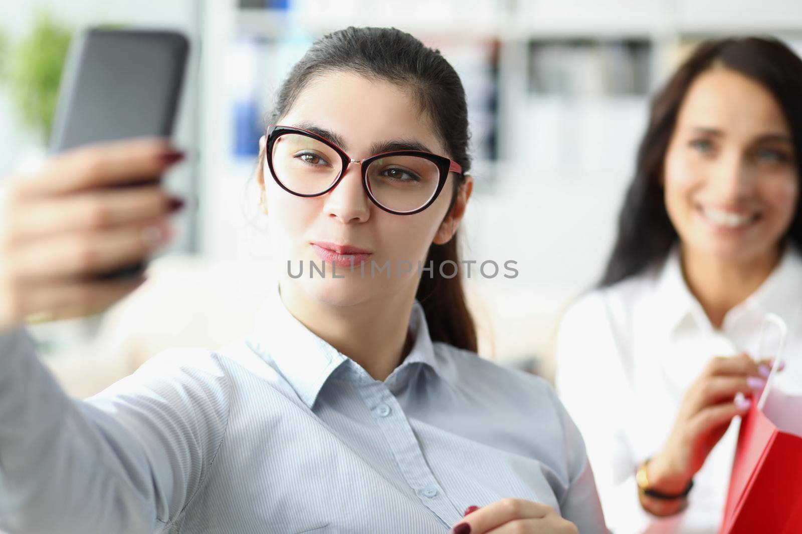 Portrait of lovely brunette women take selfie at work, pose for picture, pretty secretary in outfit work in big corporation. Business, office life concept