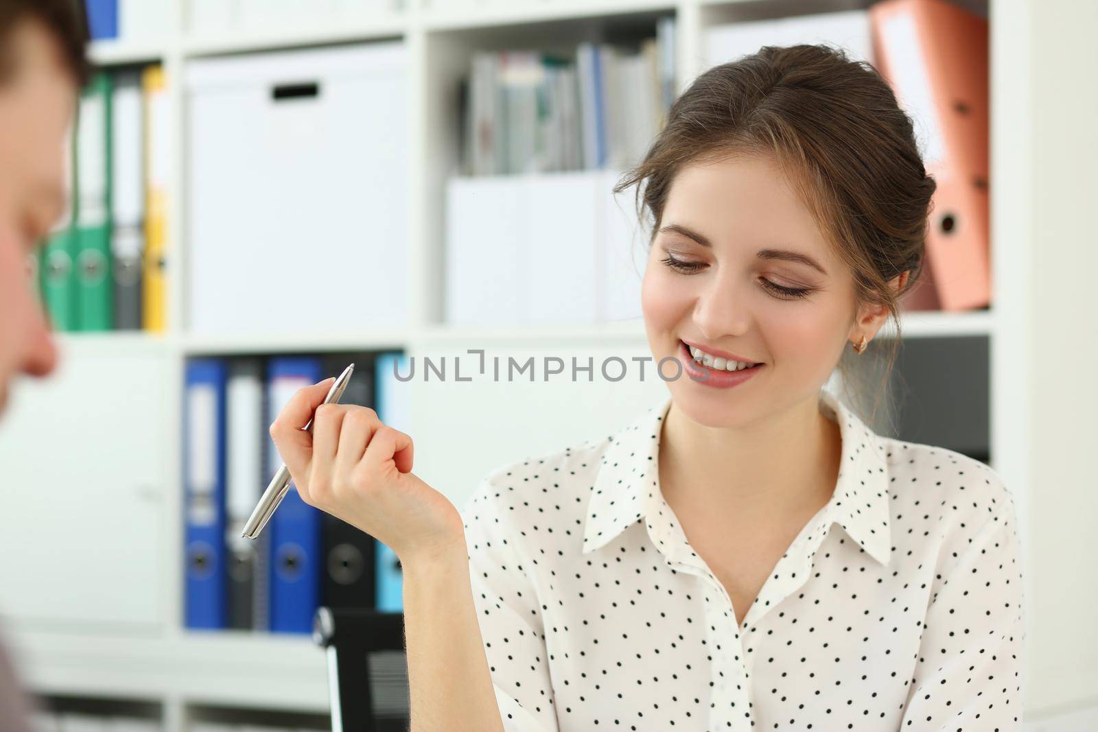 Portrait of lovely brunette secretary holding pen, planning boss meetings for day. Woman clerk in office, busy worker with task. Business, career concept