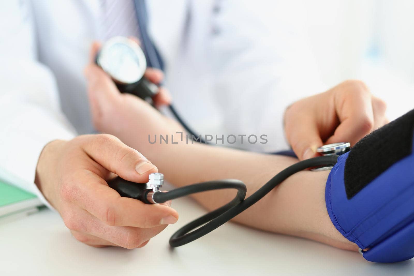 Doctor check blood pressure of patient in clinic, risk of hypertension, prevent disease by kuprevich