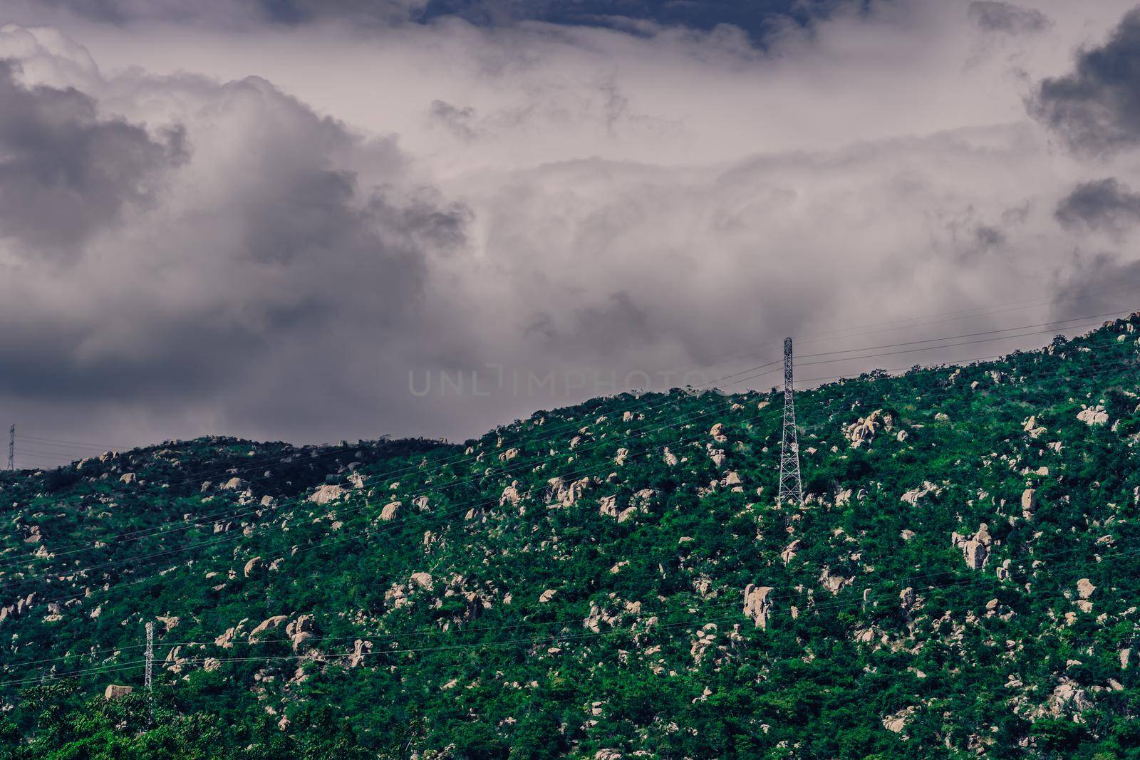 Real nature landscape background. Rocky mountain, cloudy Pale Blue dark stormy sky autumn day, high voltage Electricity power pylons. Cold mood feelings. Problem Difficult obstacles, discomfort.
