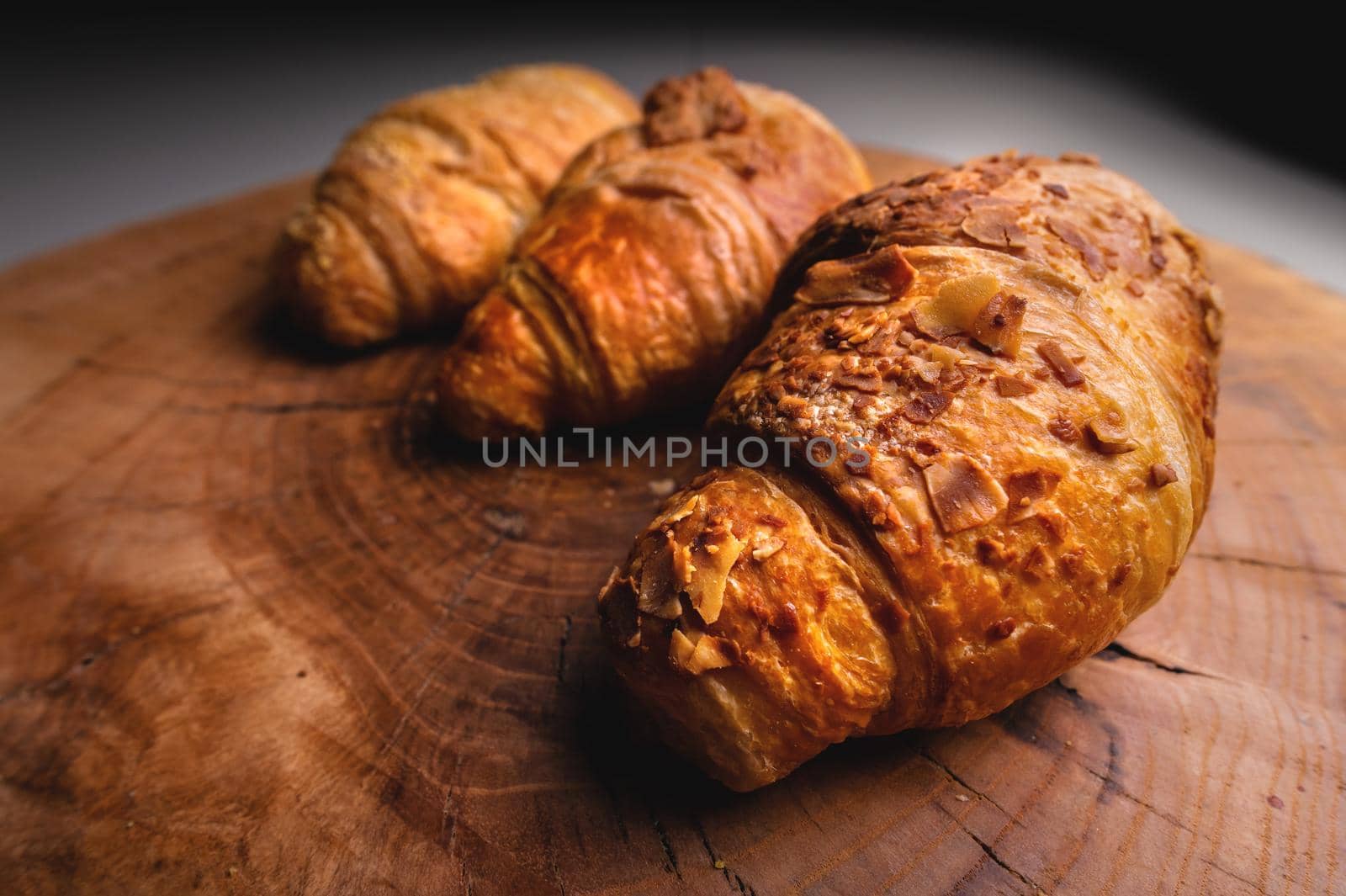 three Freshly baked croissant on a wooden Tray. Delicious and healthy breakfast.