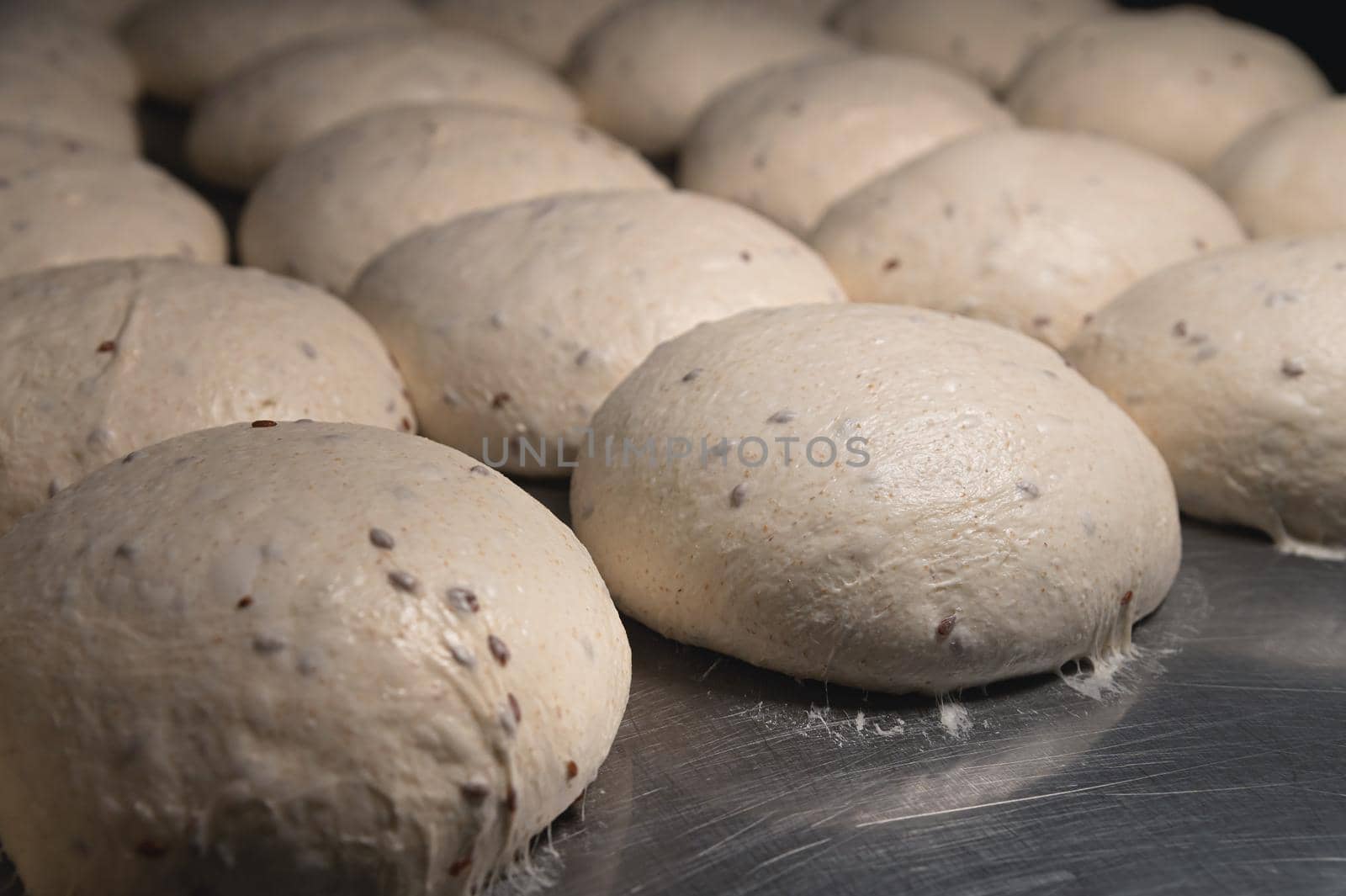 Raw burger buns dough on a metal baking sheet. Preparing ingredients for burgers by yanik88