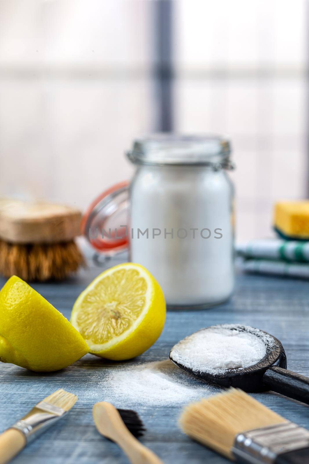 Small pile of bicarbonate in the center of lemon, brushes, sponge, brush