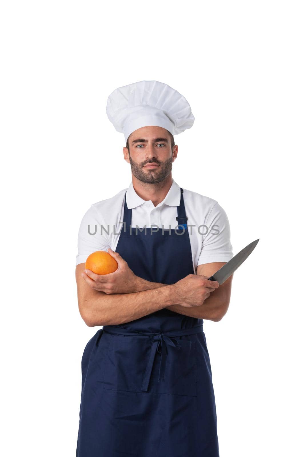 Portrait of a male cook isolated on a white studio background. Concept of professional occupation, work, job, food and restaurant industry. Caucasian young man with kitchen knife and orange