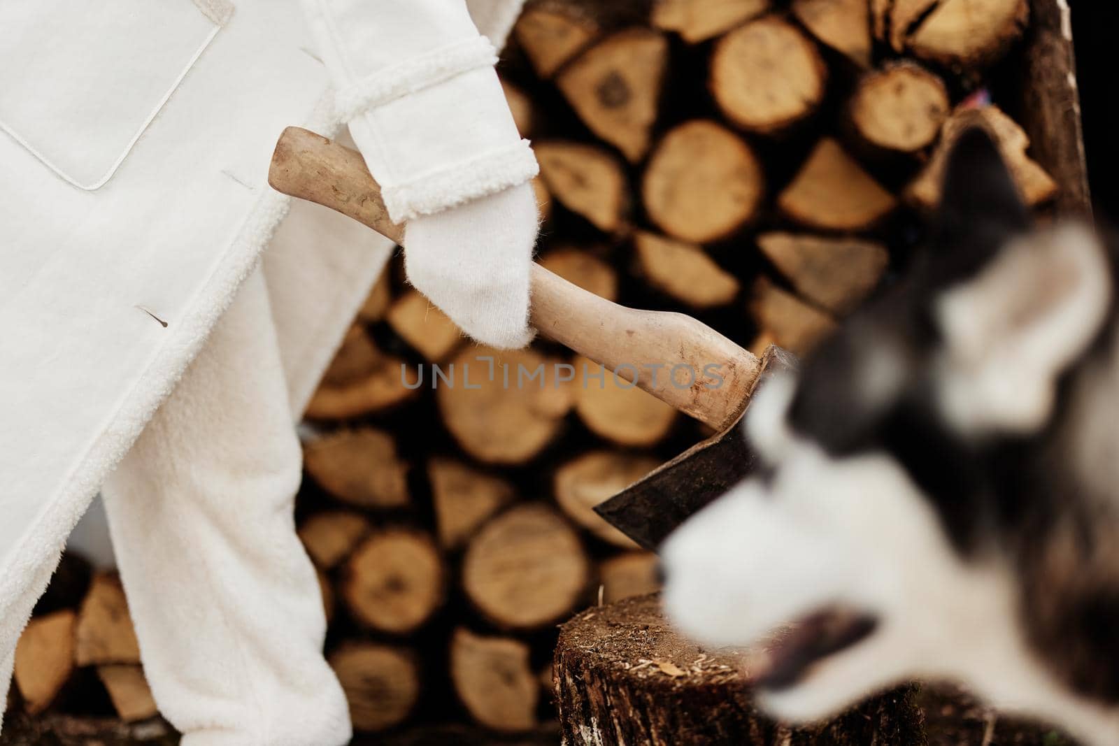 woman chopping firewood in nature in winter for heating winter holidays. High quality photo