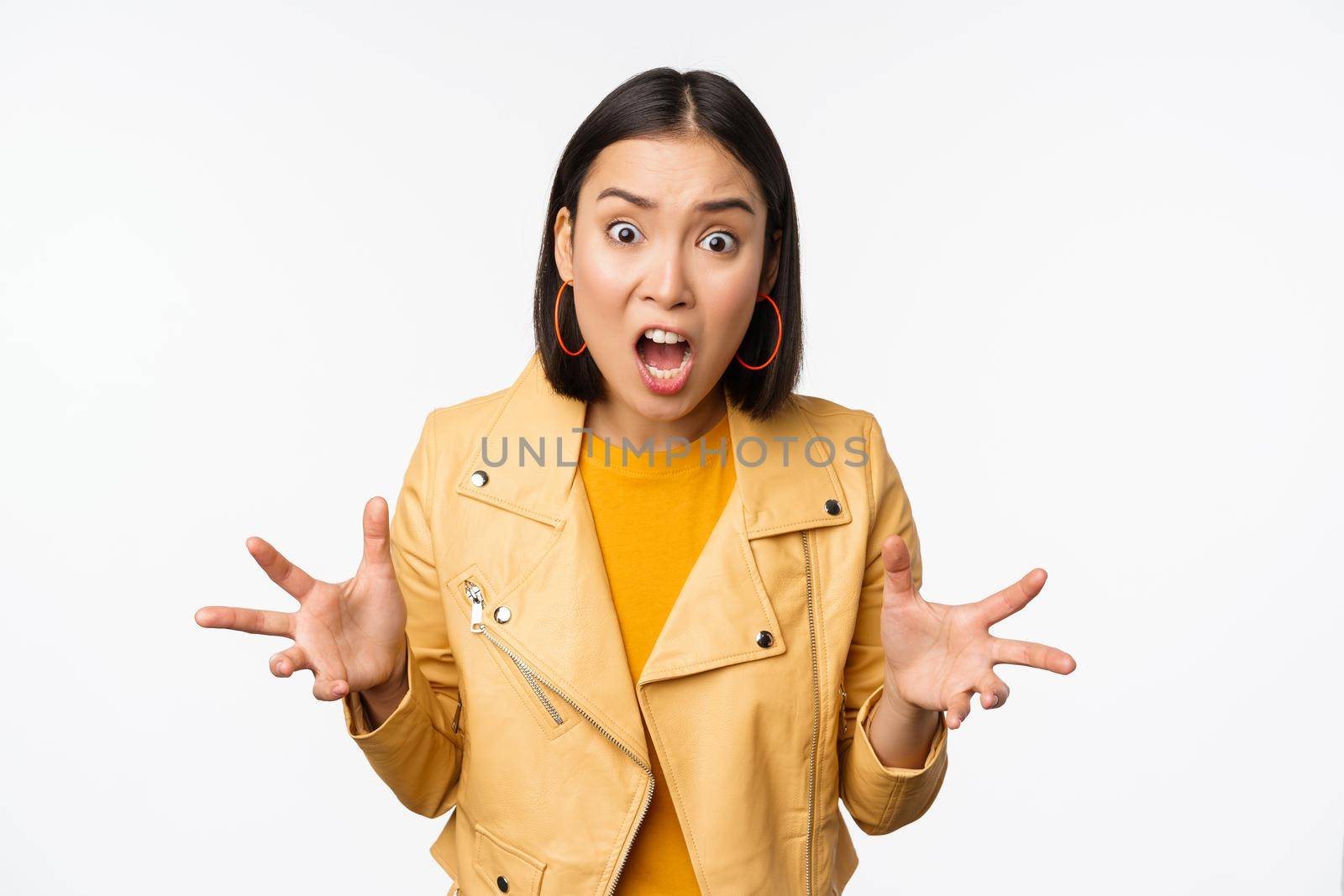 Asian angry woman arguing, shaking hands angry and screaming, shouting with frustrated face, standing over white background.