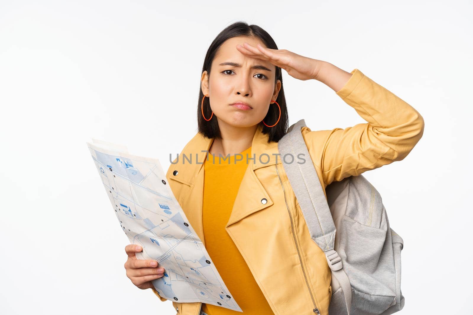 Image of young asian girl tourist, traveller with map and backpack posing against white studio background by Benzoix