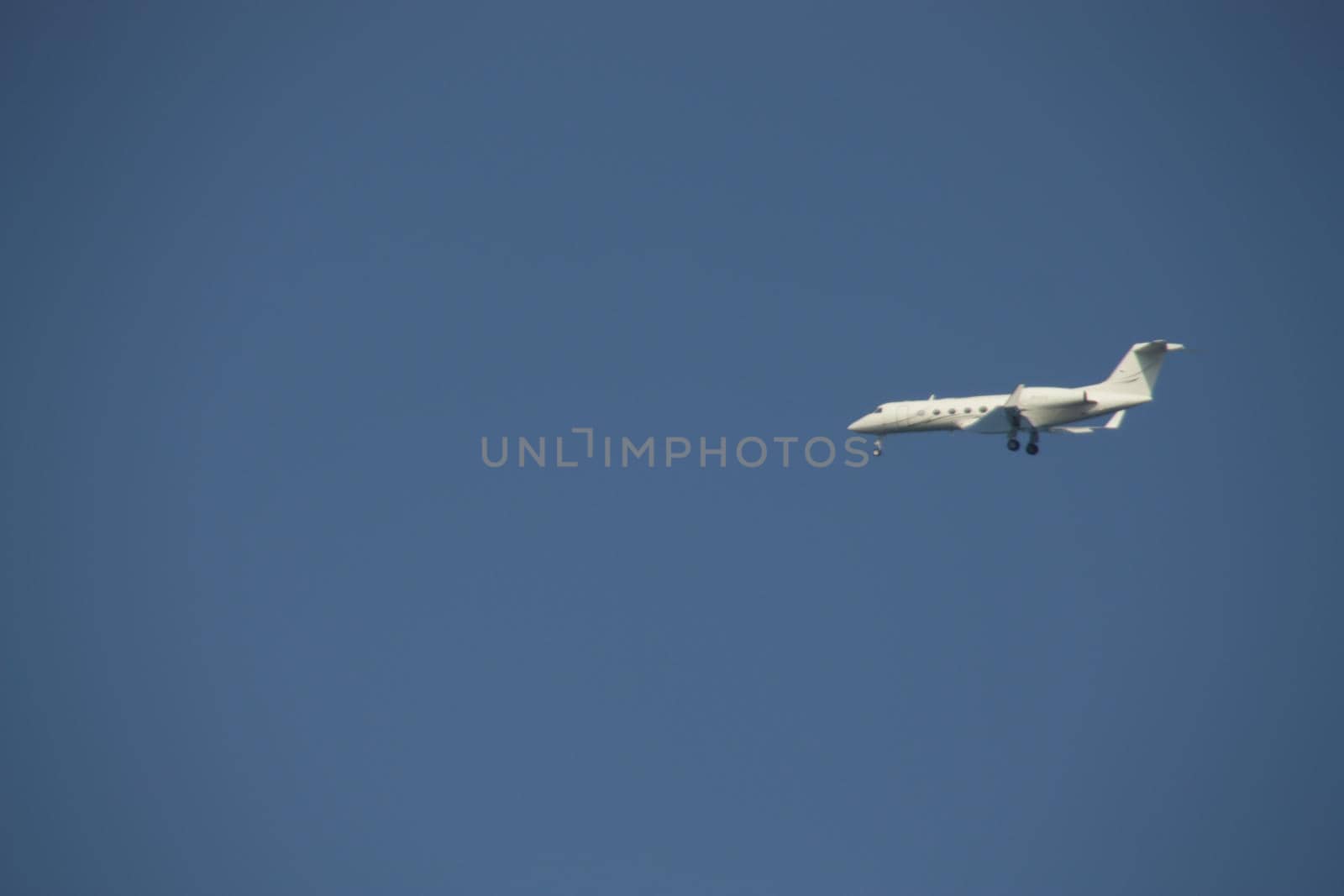 the concept of relaxing by the sea on warm sand with the sound of wave music begins in flight through the air on an airplane and landing at the airport in the photo a view of a flying plane against a blue sky. High quality photo