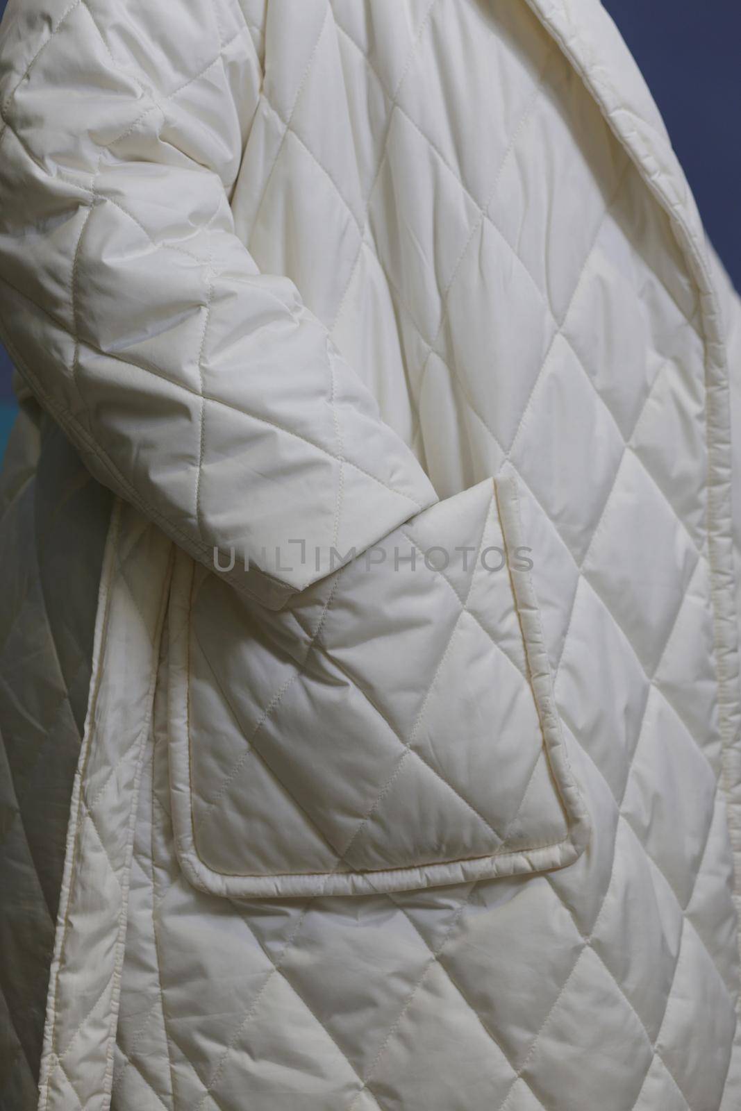 Close-up fragment of a white waterproof raincoat with a sleeve and a pocket. by gelog67