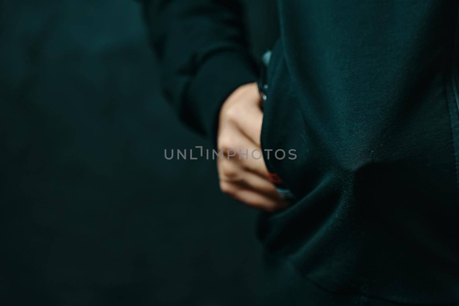 Guy is threatening with pistol in his jacket pocket. Thief hides weapon in clothes. Night criminal and robber. Close up with copy space.