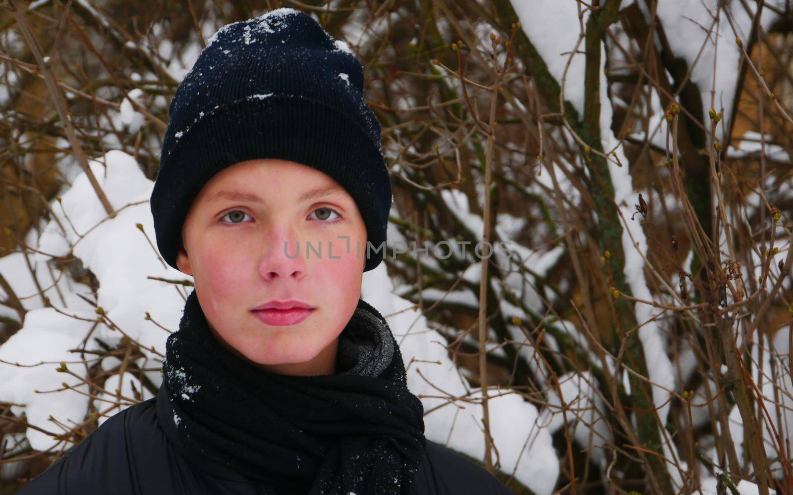 Attractive Boy 14-16 years old in a black hat and scarf close-up.