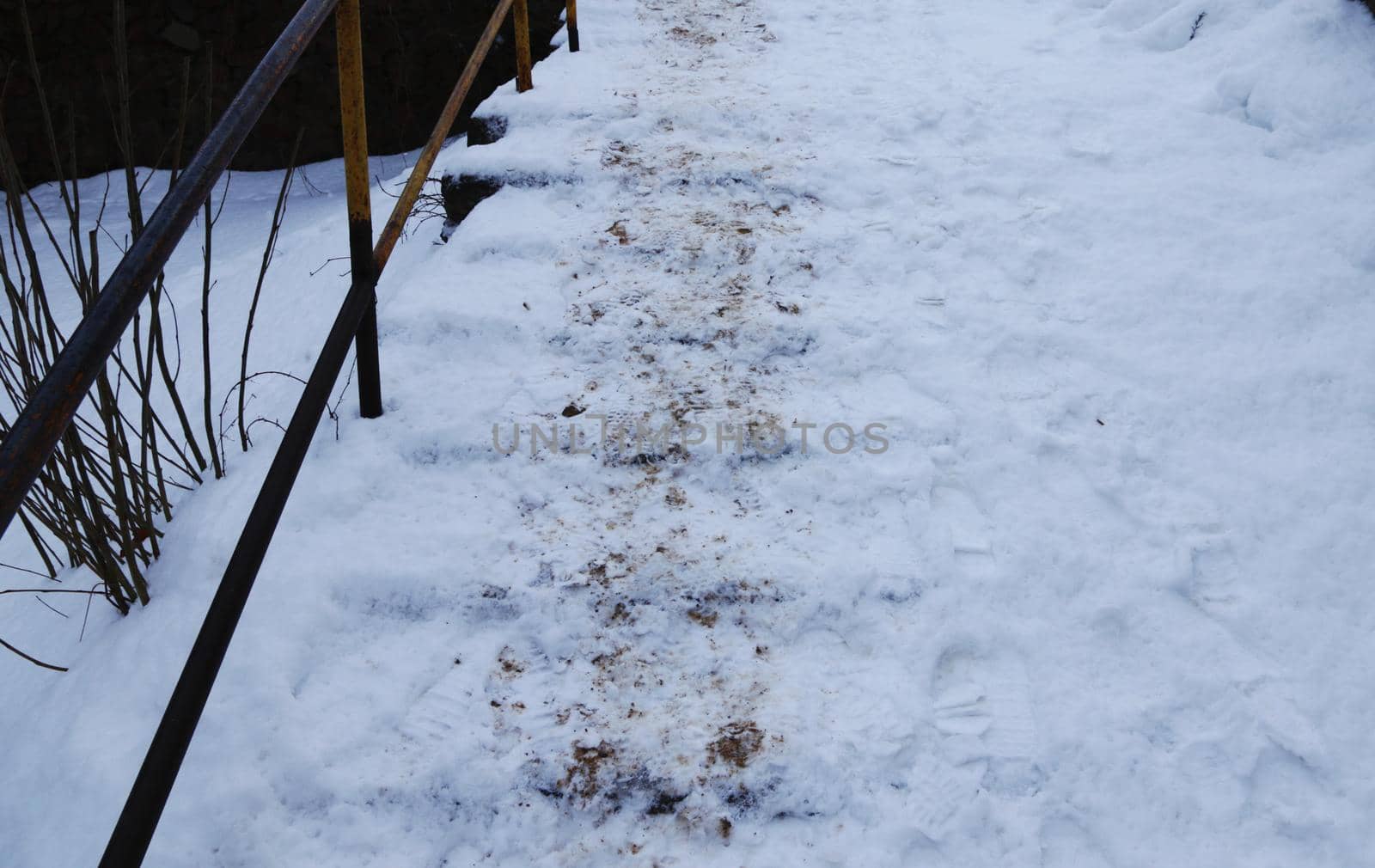 Old abandoned stairs with railings covered in snow.